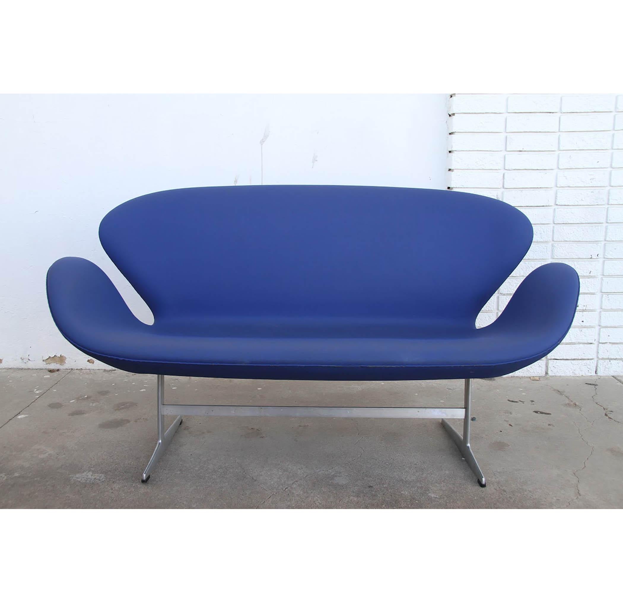 Originally designed for the SAS Royal Hotel in Copenhagen, the Swan sofa by Danish design pioneer, Arne Jacobsen, has become iconic and synonymous with Danish Modern. 

Loveseat in original hand stiched blue naugahyde upholstery designed by Arne