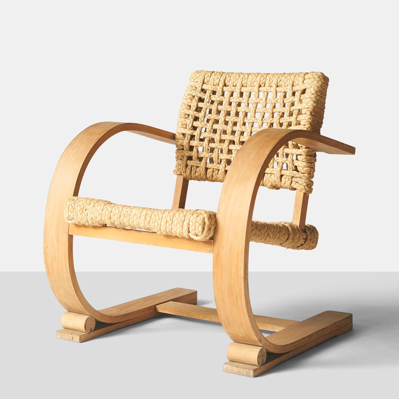 one low slung rope chair by Audoux-Minet featuring bentwood frames with braided rope seat and back rest.