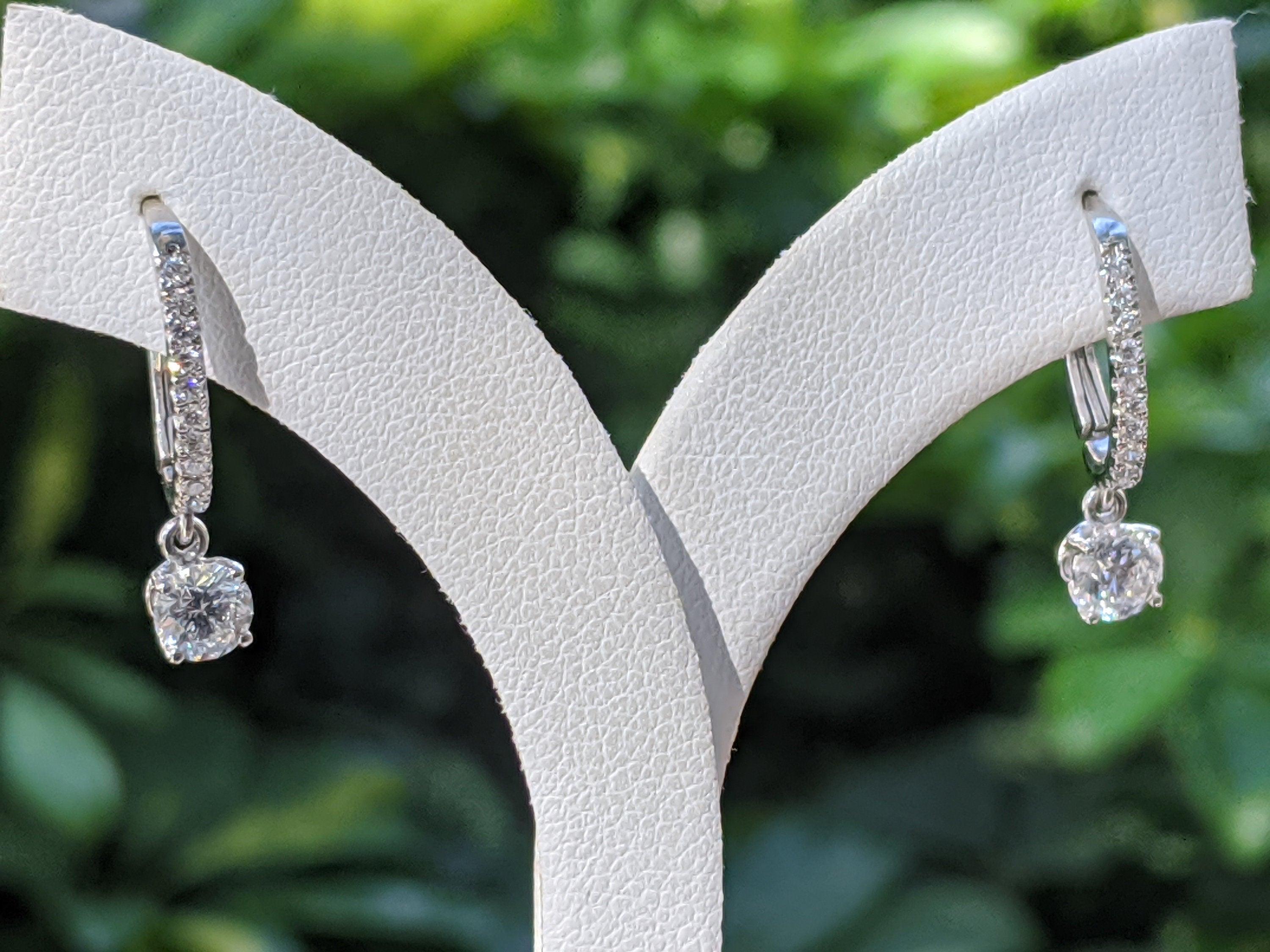 A classic solitaire diamond dangle earrings made of 14K white gold set with a pair of excellent round cut diamonds of SI1 clarity and F color.
 The total carat weight of these Diamond drop earrings is 1.00 carat.
 
 Center Stone:
 Carat Weight: 0.40