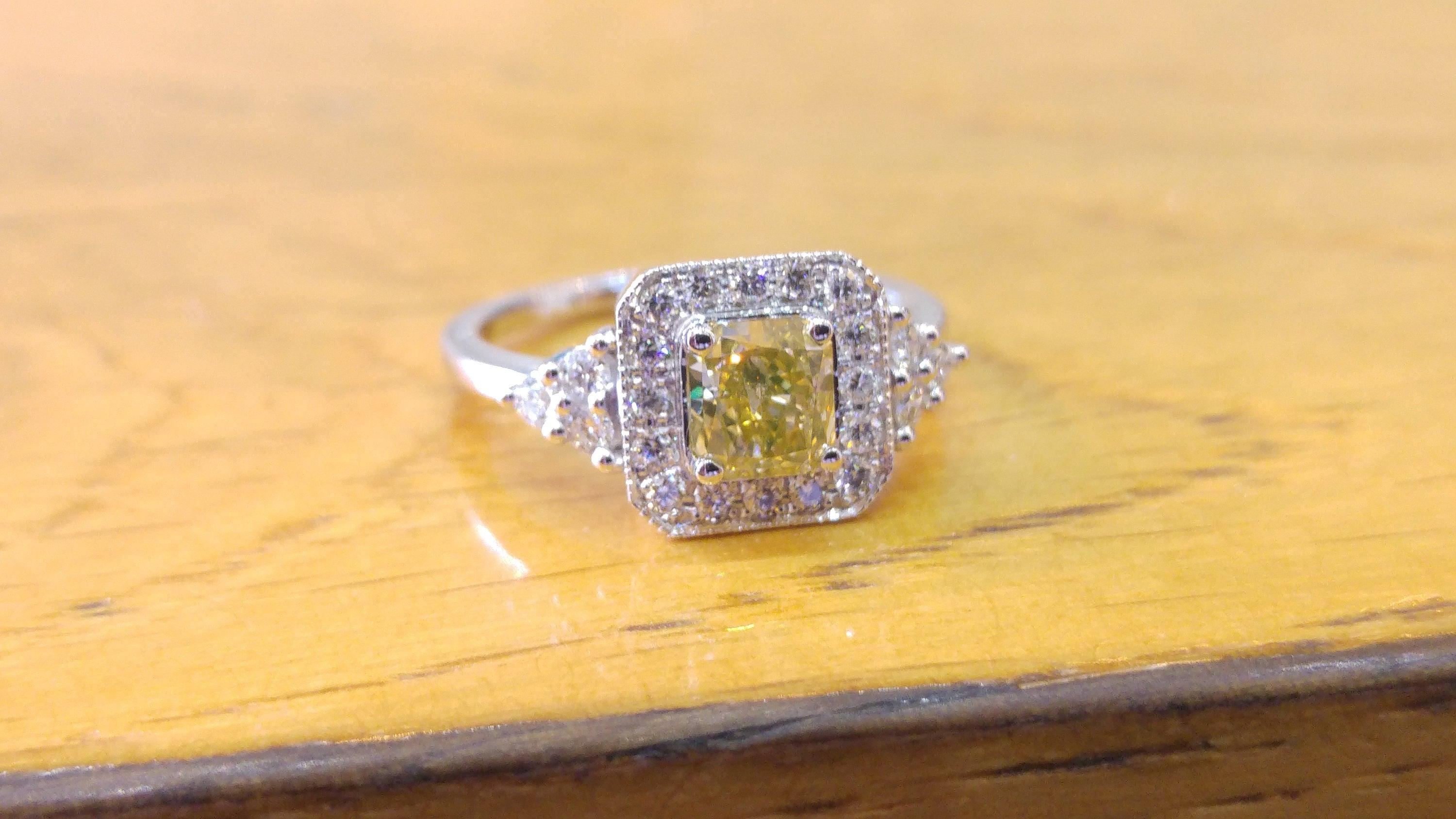 A beautiful square shaped diamond engagement ring made of 14K White Gold set with a fancy yellow diamond of 0.60ct (can be set with any stone size) accented by white round diamonds. The center diamond of this classic art deco halo ring is of