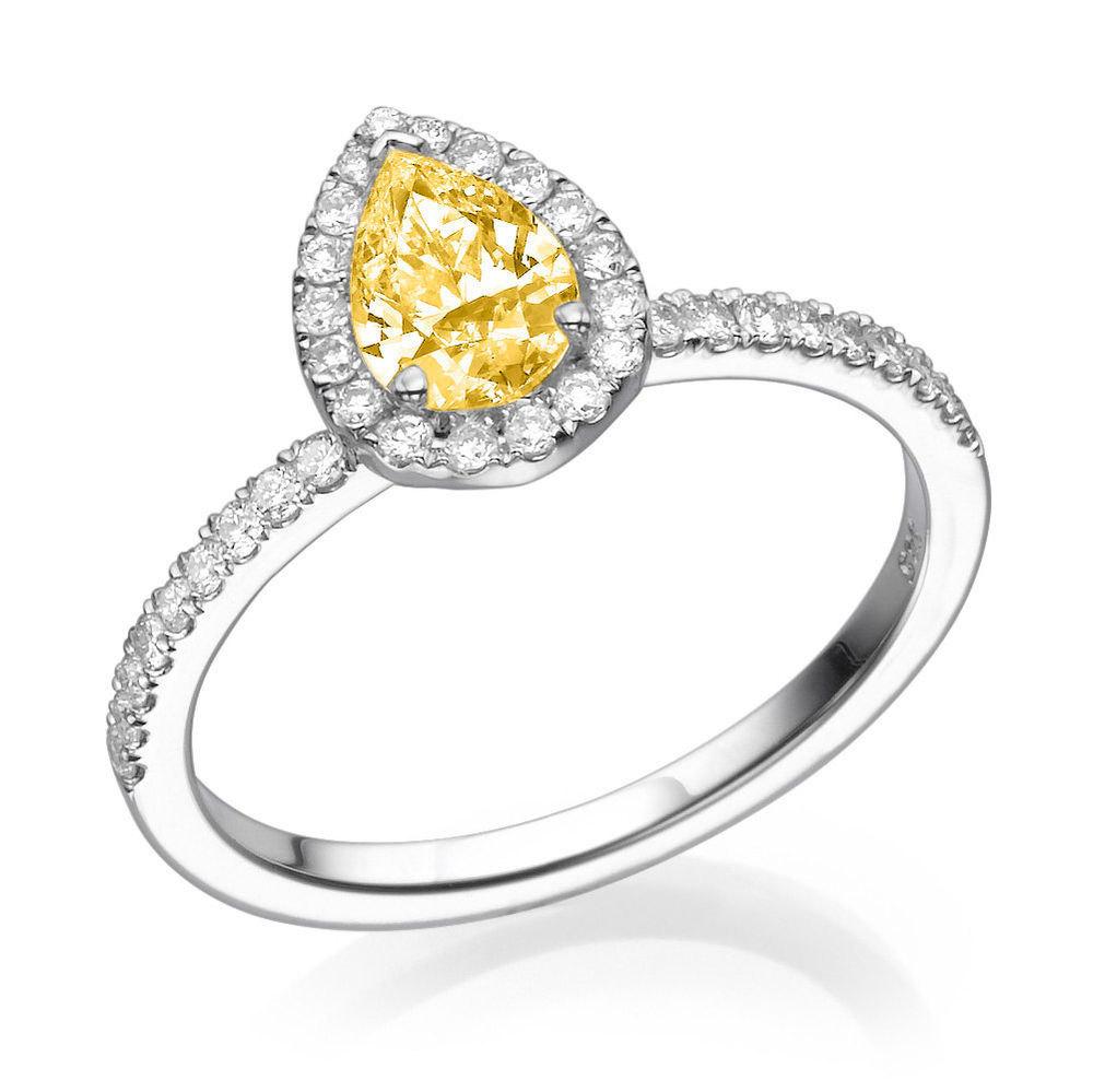 A beautiful vintage pear halo fancy yellow diamond engagement ring made of 14K White Gold set with a Pear cut Diamond of 0.70 carat accented by 36 natural round diamonds. The center stone of this unique engagement ring is of excellent cut , Fancy