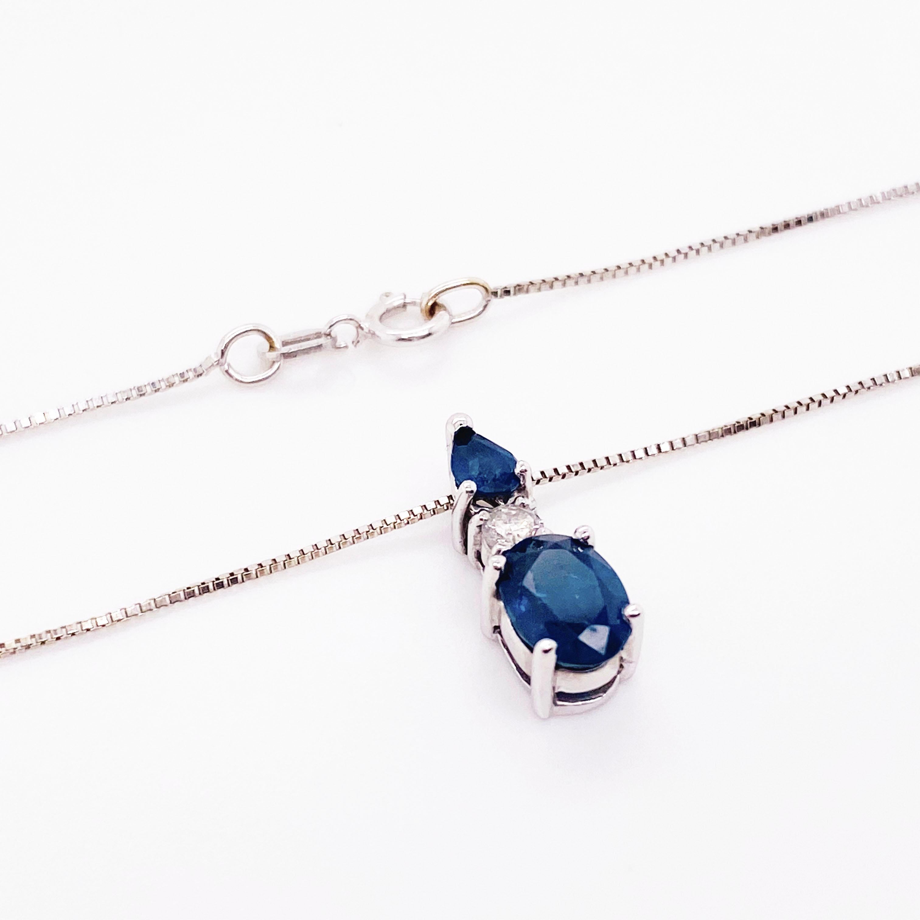 Elegant blue sapphire and diamond necklace. This striking deep blue necklace has an oval blue sapphire set in a white gold, four prong setting. Sitting on top of the sapphire is a round brilliant diamond with a pear shape blue sapphire on top of it.