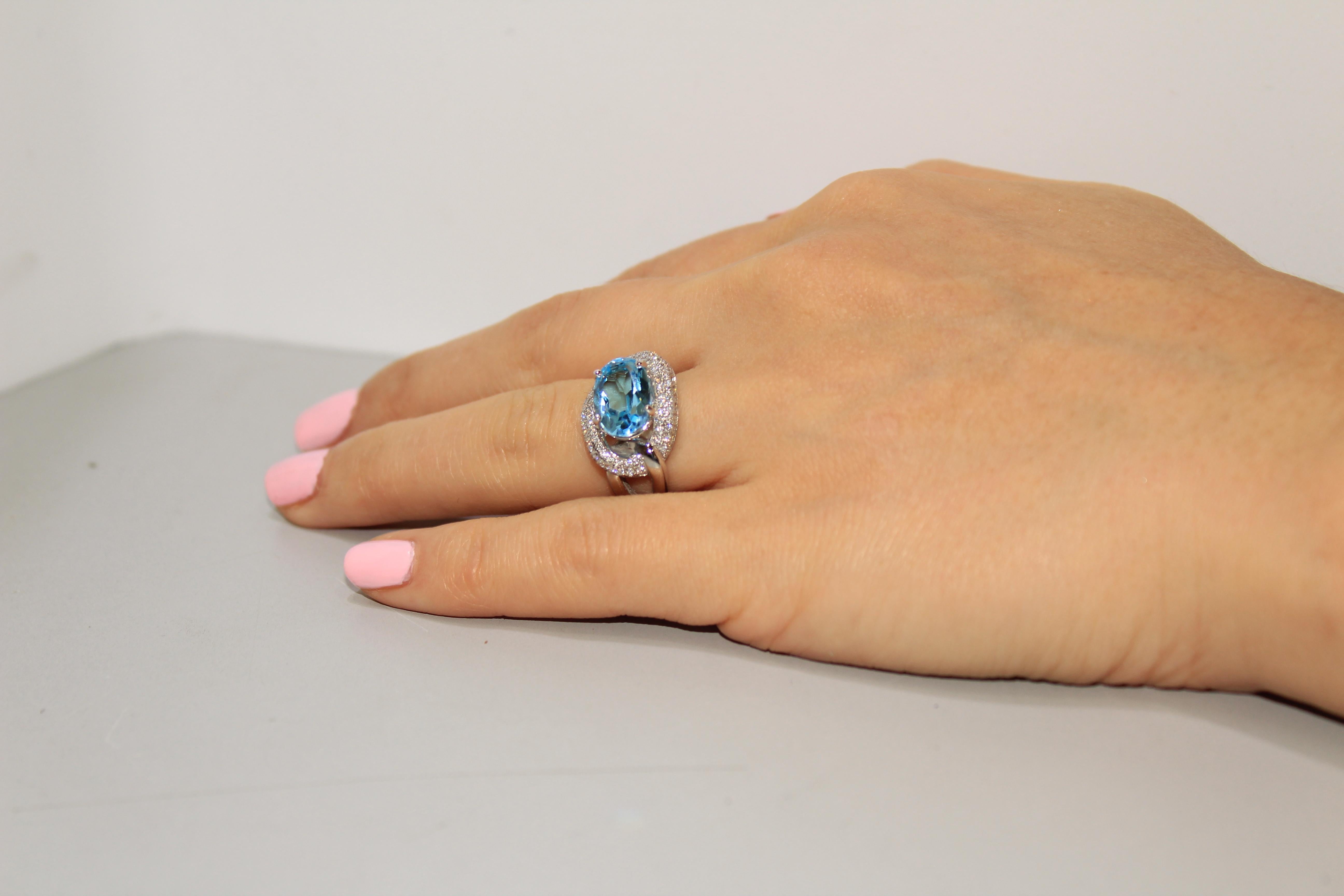 Oval Cut 1 Carat Blue Topaz with Diamond Halo Set in an 18 Karat Gold Engagement Ring For Sale