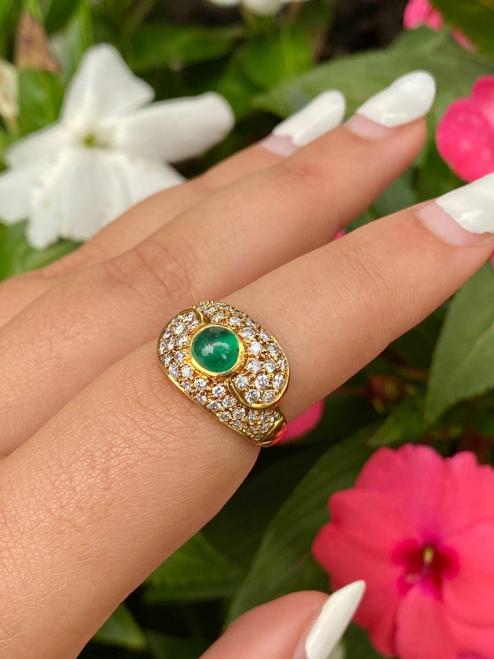 Cabochon cut natural Colombian Emerald mounted in 18k yellow gold. Set with 1.02 carats in a round-cut natural diamond cluster.

✔ Natural Emerald
✔ Natural Diamonds
✔ Gold Karat: 18K
✔ Emerald Shape: Cabochon
✔ Emerald Weight: 0.90 carats
✔ Emerald