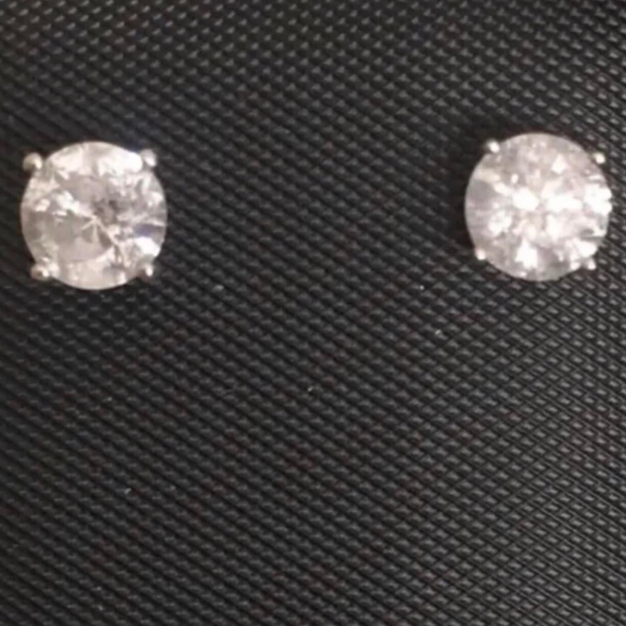 Boucles d'oreilles classiques en or blanc 14 carats et diamant solitaire de 1 carat. Une paire de diamants ronds et brillants d'un poids approximatif de 1,02 carat sont sertis dans ces clous d'oreilles en forme de panier de 14 carats.

Les boucles