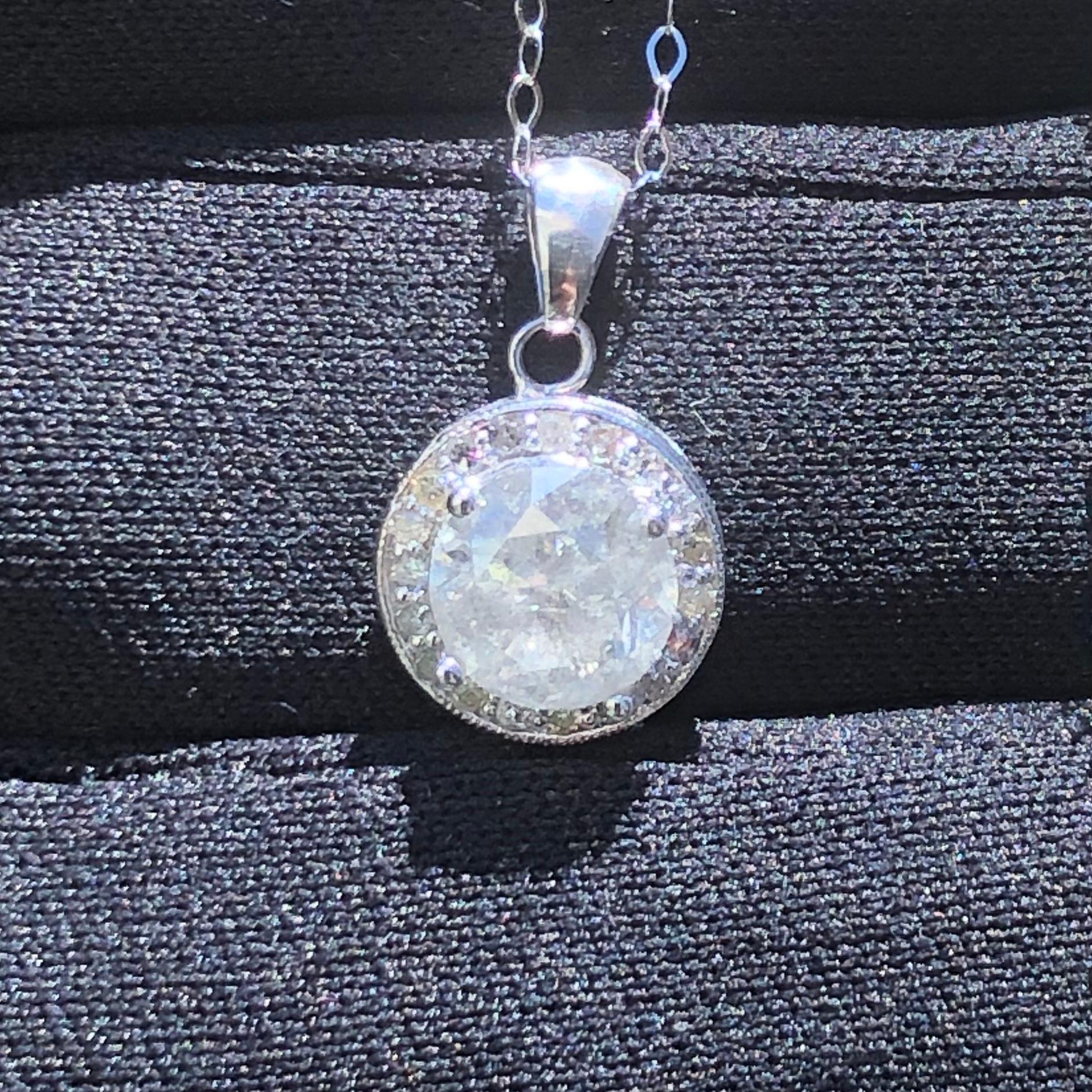 Opulent approx. 1.76 carat solitaire round diamond pendant in 14k white gold with necklace chain. A center brilliant round diamond weighing approx. 1.76 carats (natural earth-mined diamond enhanced) surrounded by approx. 1/3 carats of halo side