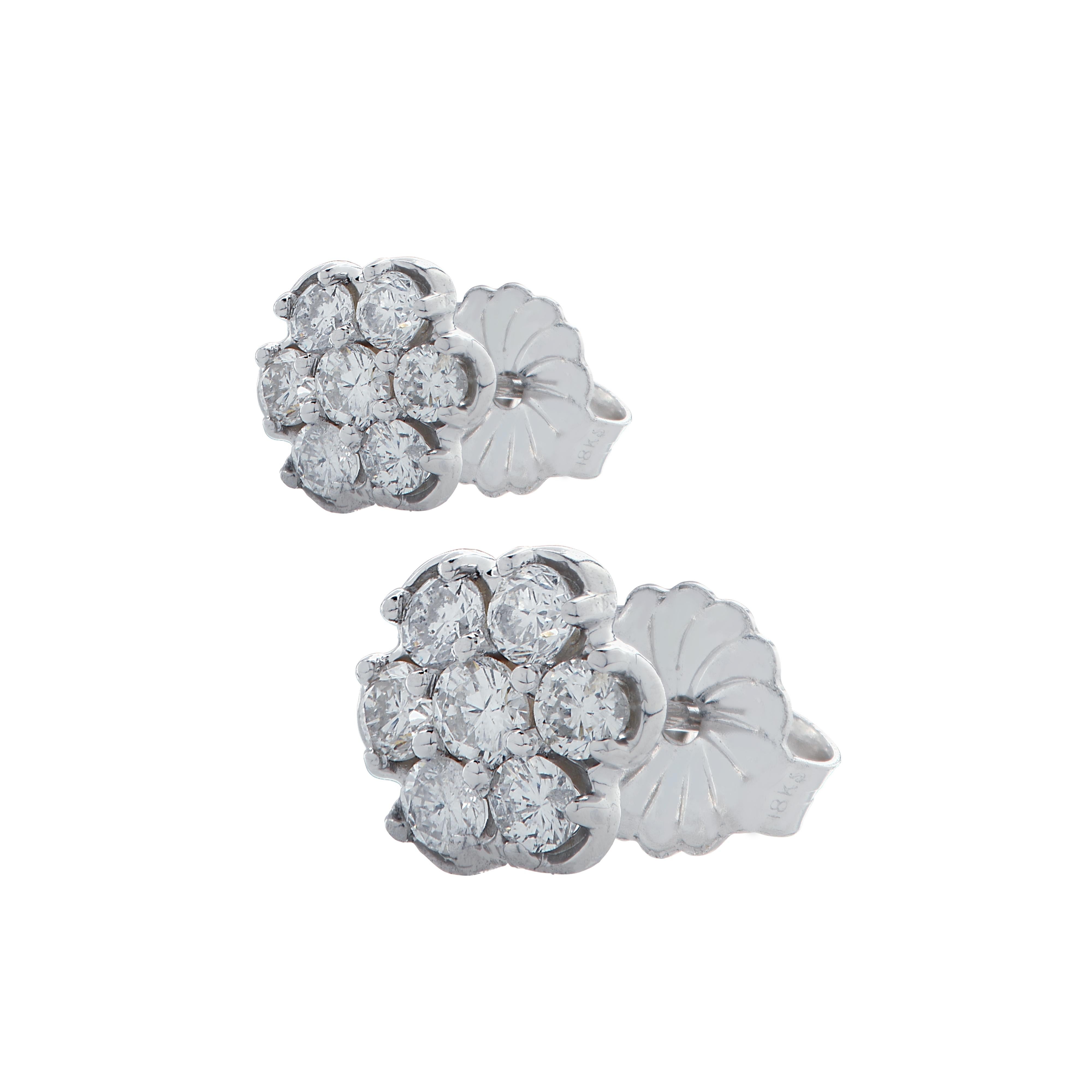 Delightful stud earrings crafted in white gold, featuring 14 round brilliant cut diamonds weighing 1 carat total, G color, VS-SI clarity, arranged in a flower design that captures the unparalleled beauty of nature.  These whimsical earrings measure