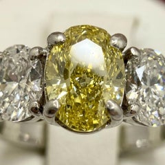 1 Carat Fancy Yellow Diamond Three-Stone Oval Diamond Ring