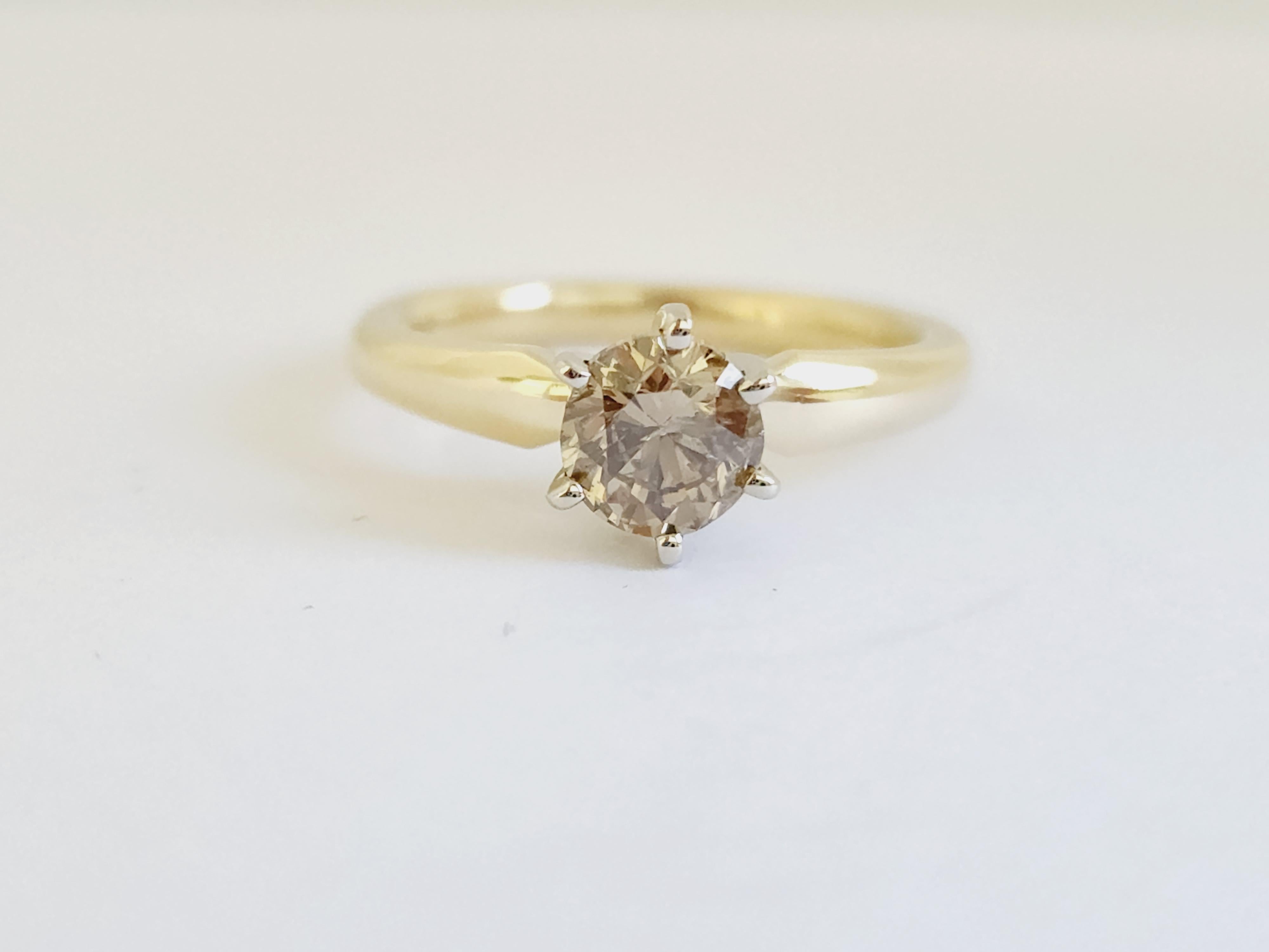 Natural fancy dark yellow brown round diamond weighing 1 carats. Set on 6-prong 14K yellow gold.
Ring size: 6.5