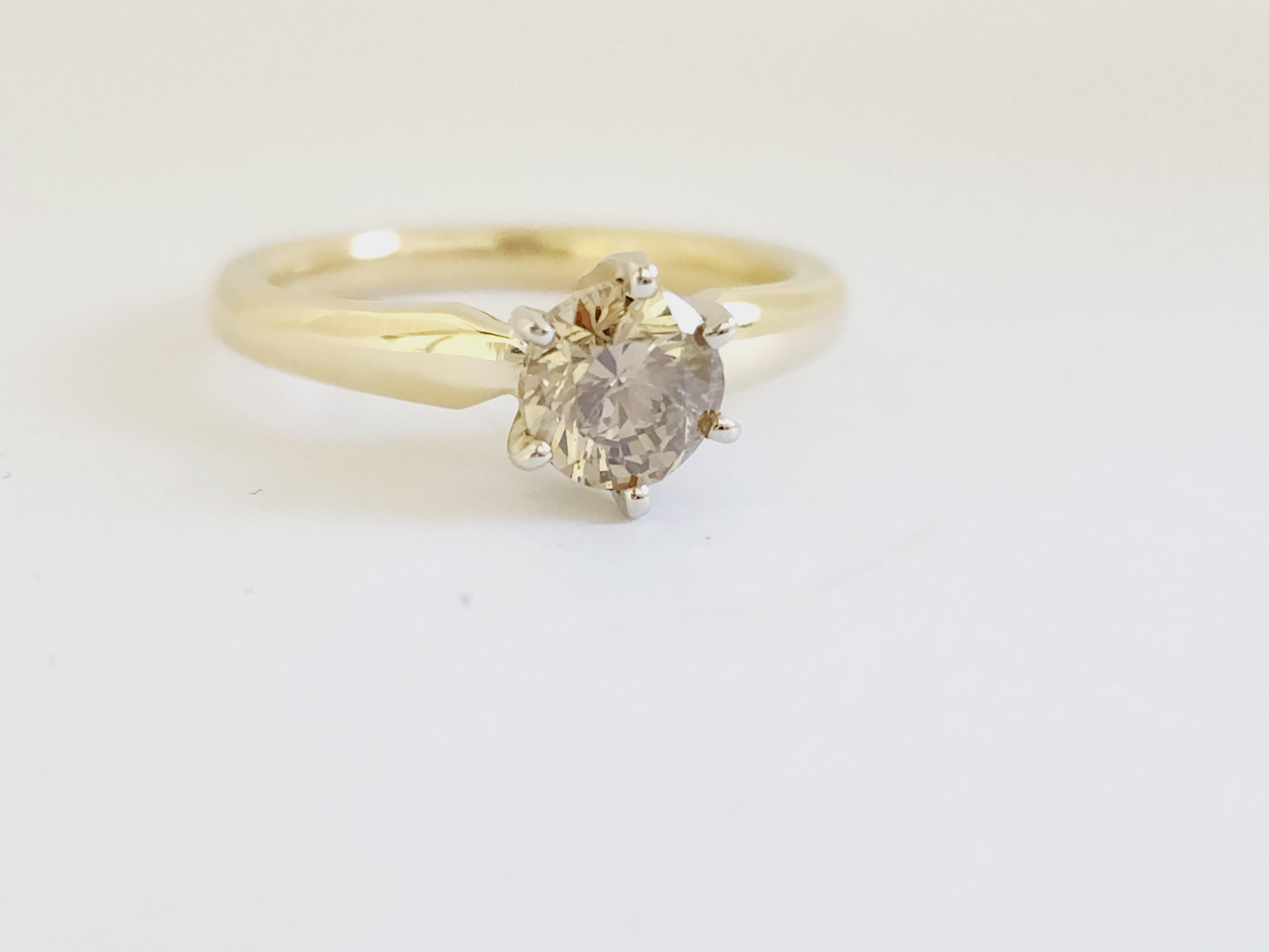 Natural fancy dark yellow brown round diamond weighing 1 carats. 
Set on 6-prong 14K yellow gold.
Ring size: 6.5