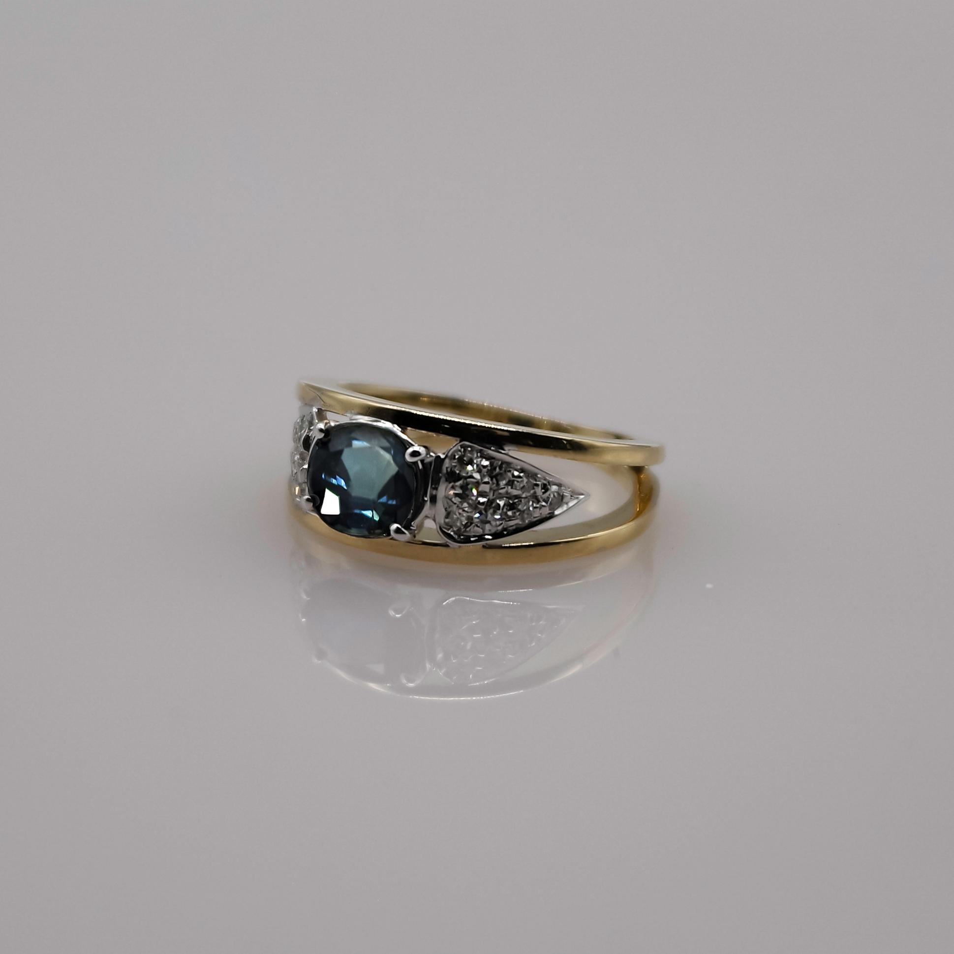 Ring in 18 Karat yellow and white gold, with a beautiful dark greenish blue and trasparent sapphire, well set with 4 prongs. Weight estimated at 1.00 carat.

The central stone is surrunded by 16 round brilliant diamonds pavé set in 18 karat white