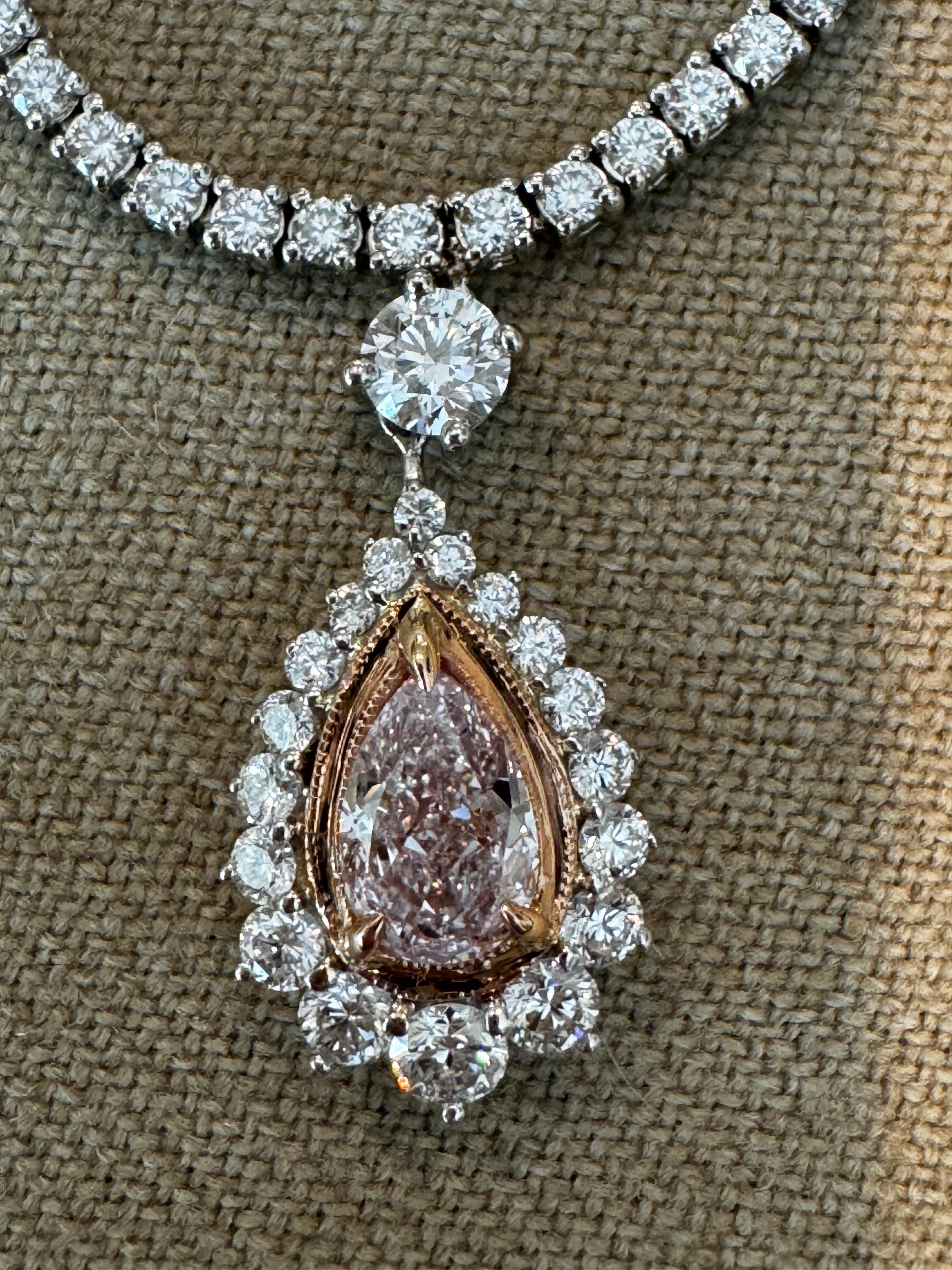 Eccezionale collana con ciondolo di diamanti rosa chiaro da 1,00 carati
Una dichiarazione di eleganza mozzafiato, questa collana presenta un raro diamante Light Diamond a forma di pera da 1,00 carati (purezza VS2), graziosamente incorniciato da una