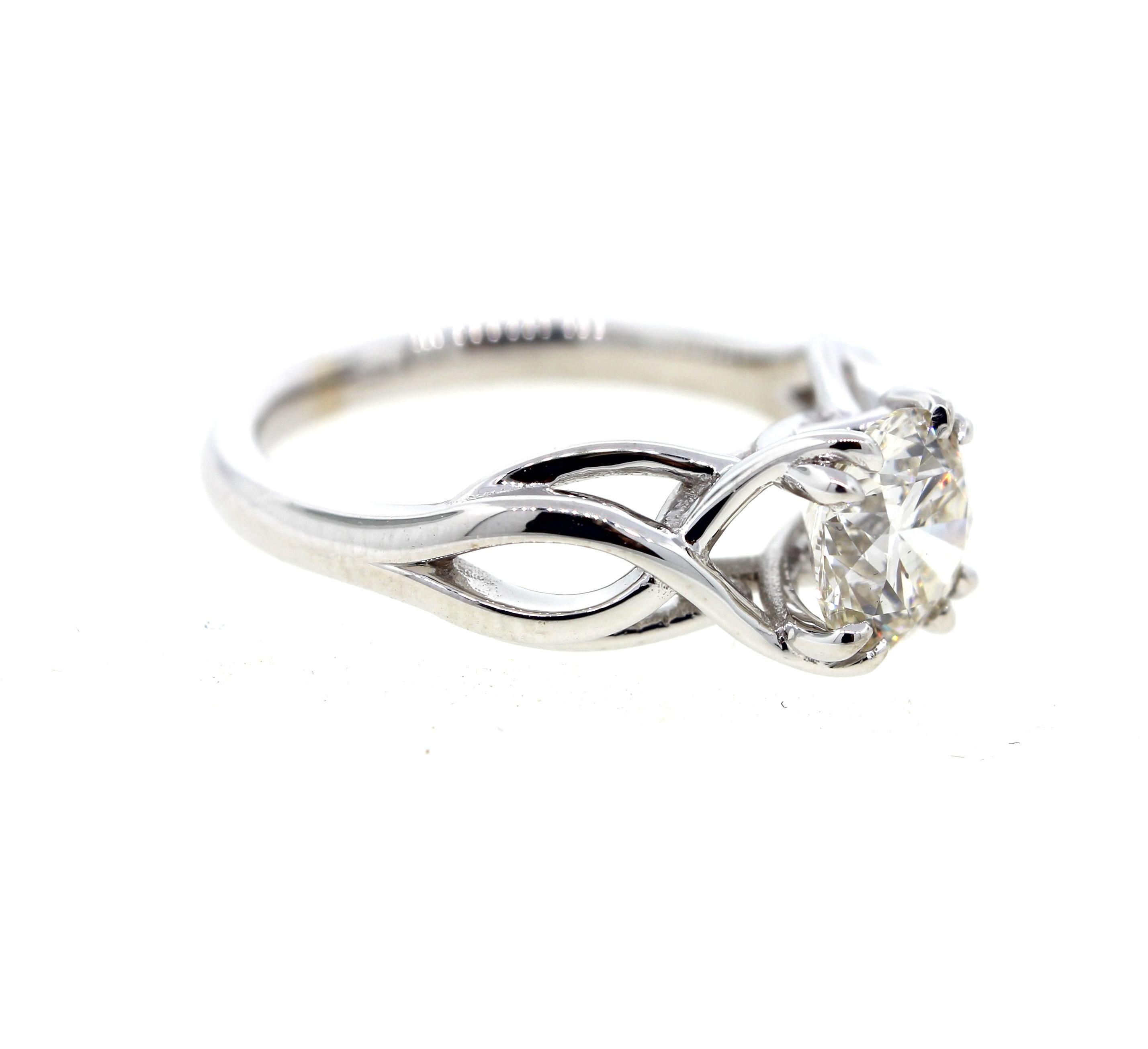 This twisted diamond engagement ring is crafted in 18k white gold, and contains a Round Brilliant Cut Diamond (1.00 carats, H color, and VVS2 clarity).  A classic take on the traditional solitaire, this ring has a matching flush fit wedding band