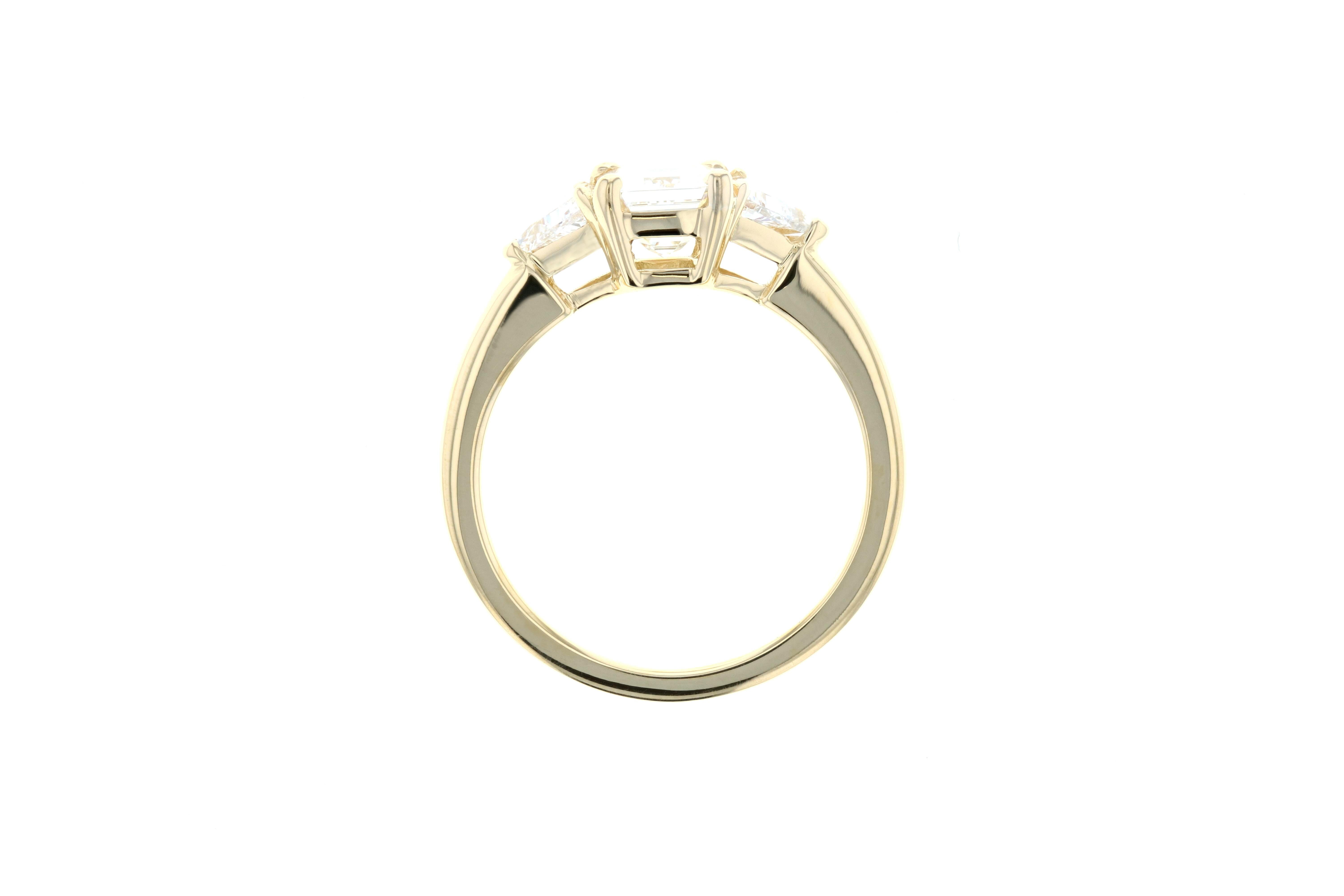This engagement ring has a 1 carat center diamond and two diamond side trillions with a yellow gold setting and a gallery profile for a vintage look and feel. 


Though this diamond ring is shown in yellow gold and with an emerald cut center stone,
