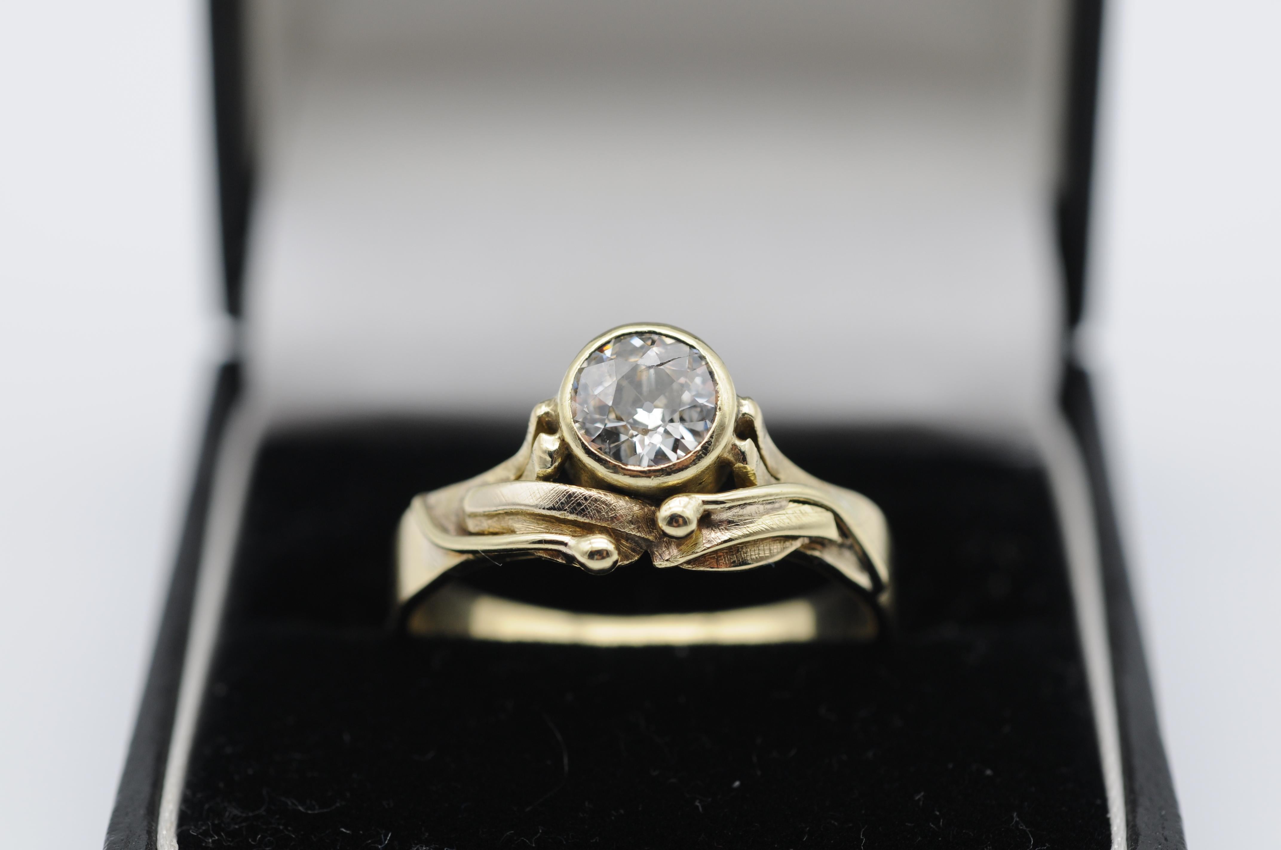 Step into the luxurious world of Art Nouveau with this exquisite 14K yellow gold solitaire ring. The timeless design is perfect for the fashion-forward individual who values both elegance and sophistication.

The centerpiece of this ring is a