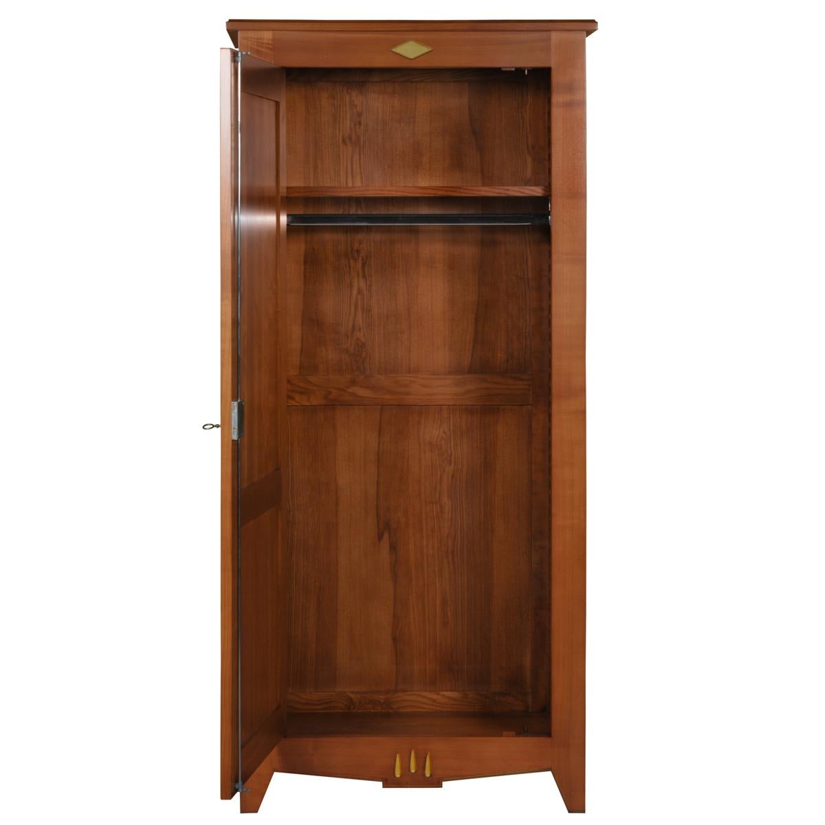 This wooden closet is offered in solid French cherrywood and is also available in oak. 
 
The hanging bar is fixed under a wooden shelf. This shelf is height-adjustable on a wooden rack. 
The oval entrance and key are in brass and fitted with a