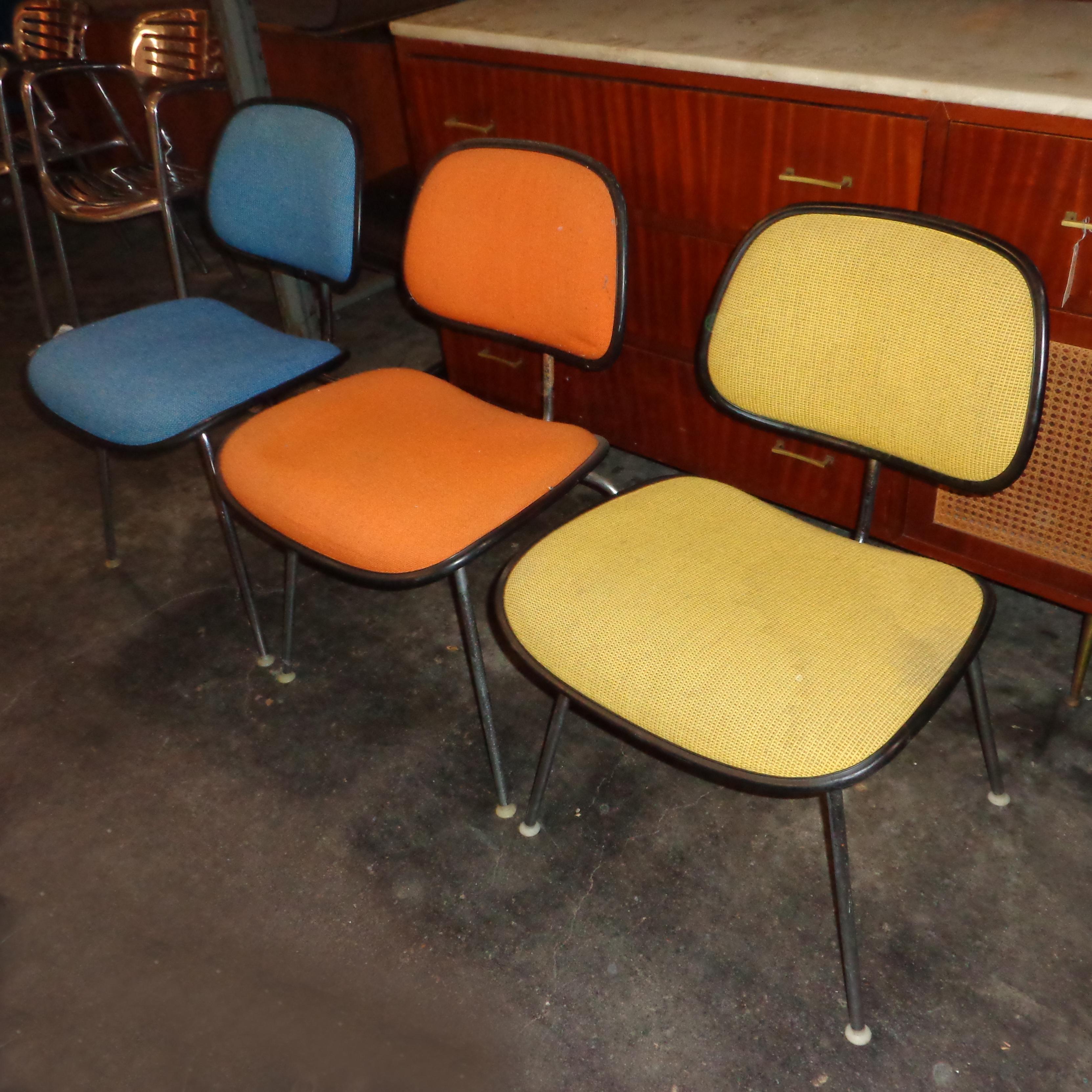D'un design classique des Eames, ces DCM (Dining Chair Metal) sont disponibles dans une variété de couleurs. L'assise et le dossier sont rembourrés et bordés de caoutchouc noir, le dossier, le support et les pieds sont en métal chromé. Le siège et