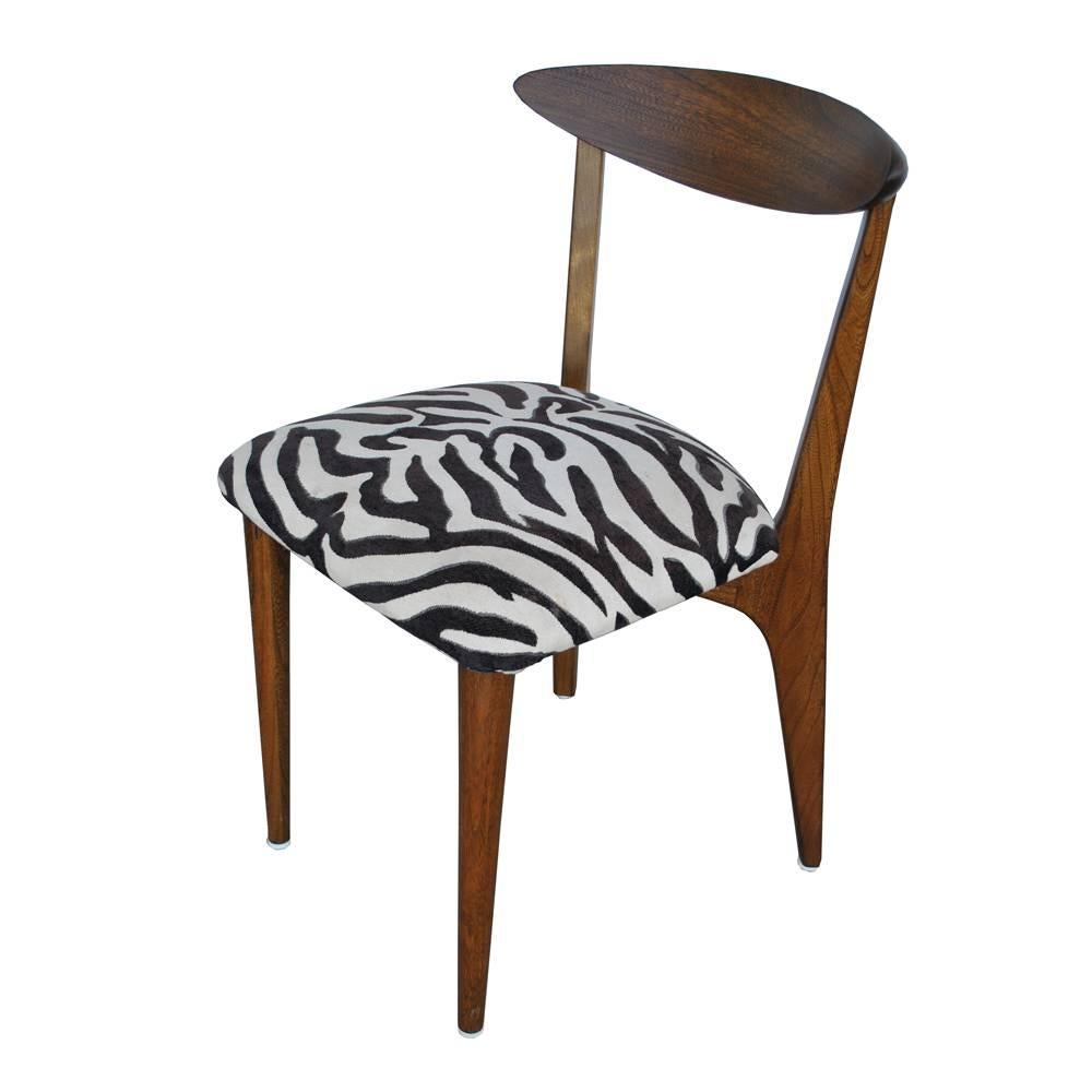 One dining chair in the manner of Kurt Ostervig 

Danish modern solid wood in a walnut finish in the style of Kurt Ostervig.
Sculptural and elegant with an X-base support. Restored and reupholstered in a zebra print.

Six available.