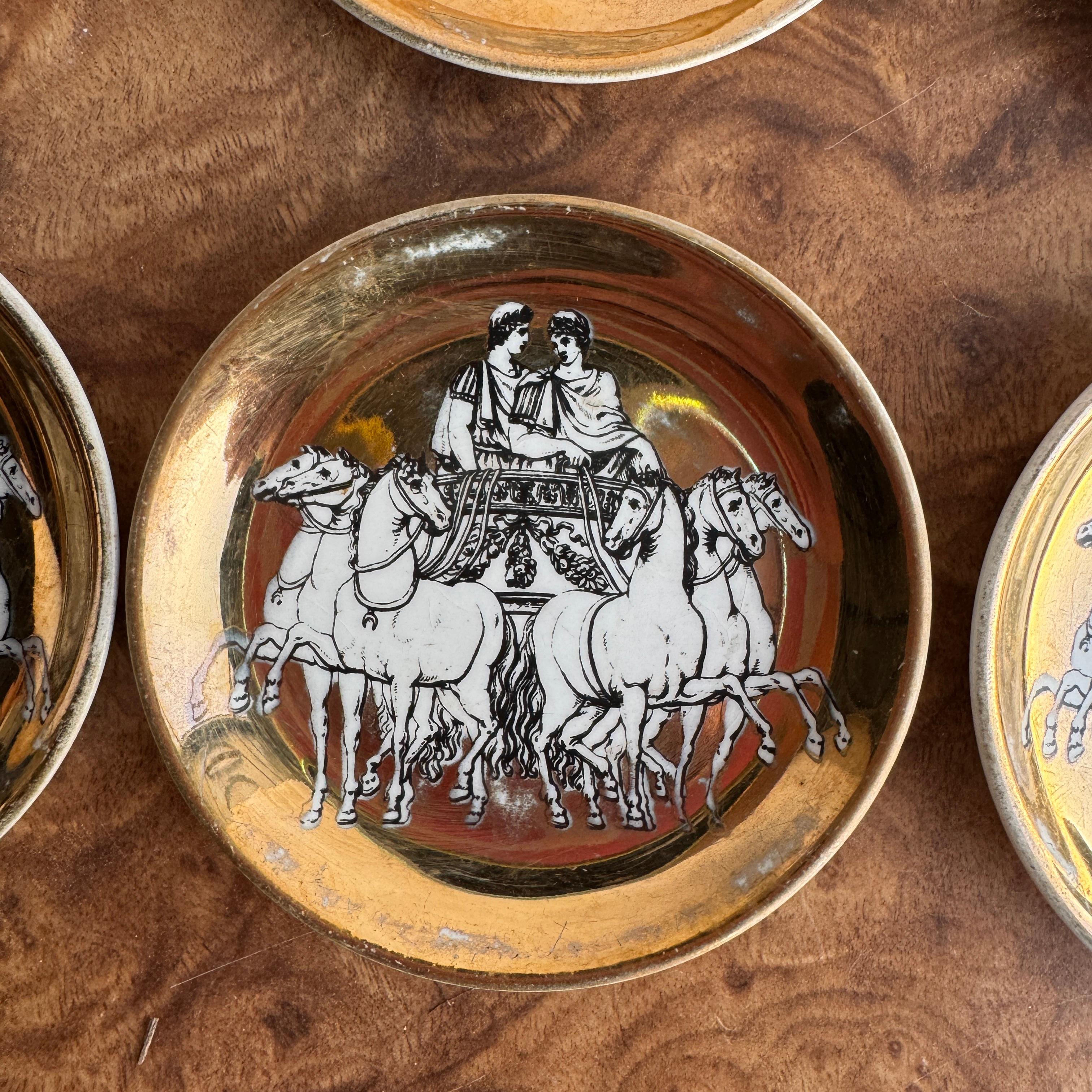 Vintage mid century modern Fornasetti coasters, set of six (6) of chariots with horses with gold gilding. Some noticeable wear to the gold coloring on the faces of the coasters. No chips or cracks. Marked on the backs Fornasetti Made in Italy. 