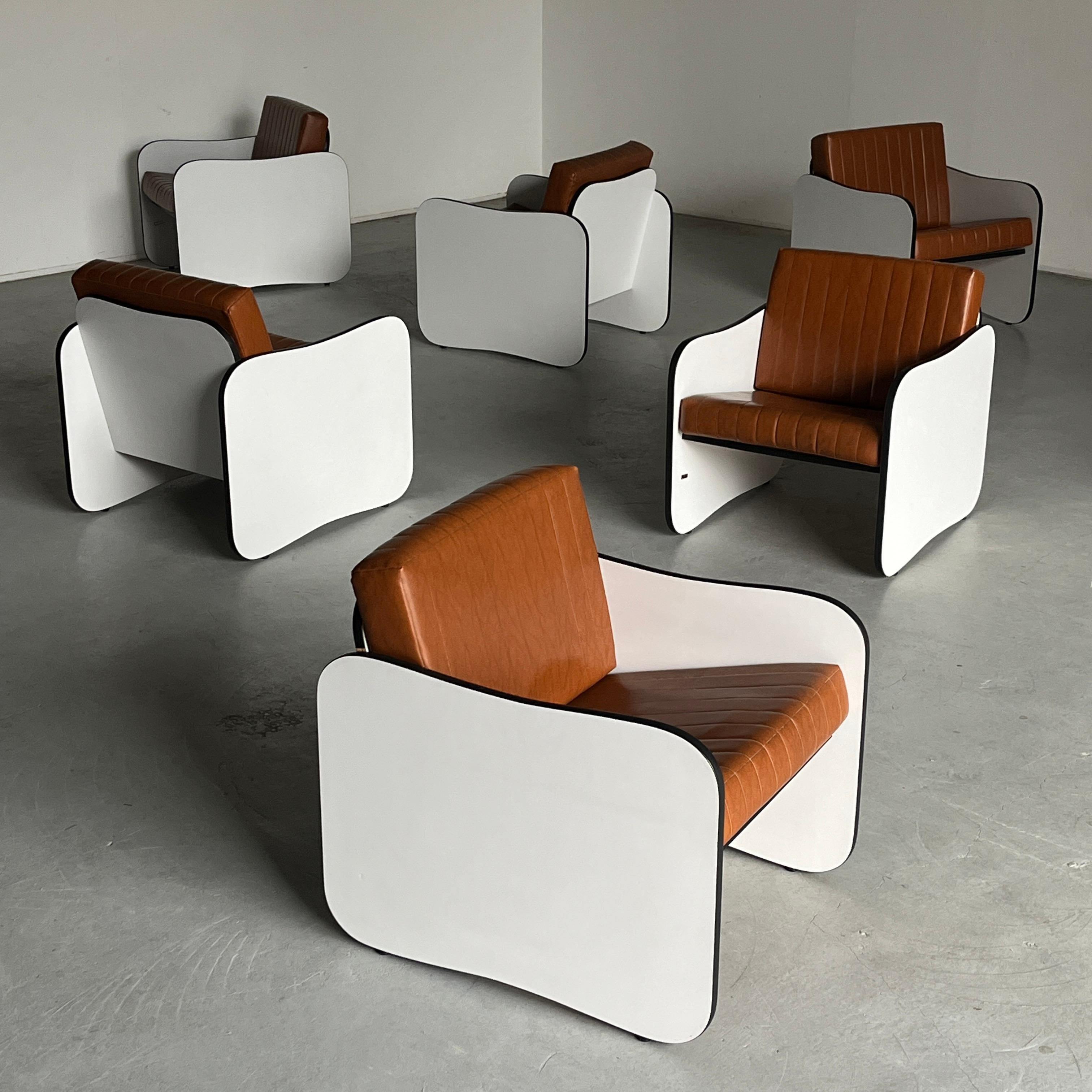 One of twelve mid-century modern armchairs composed of a white wooden frame and two cushions in brown faux leather. Heavy and sturdy.

In good vintage condition with smaller expected signs of age, as shown in the photos. The wooden frames are in