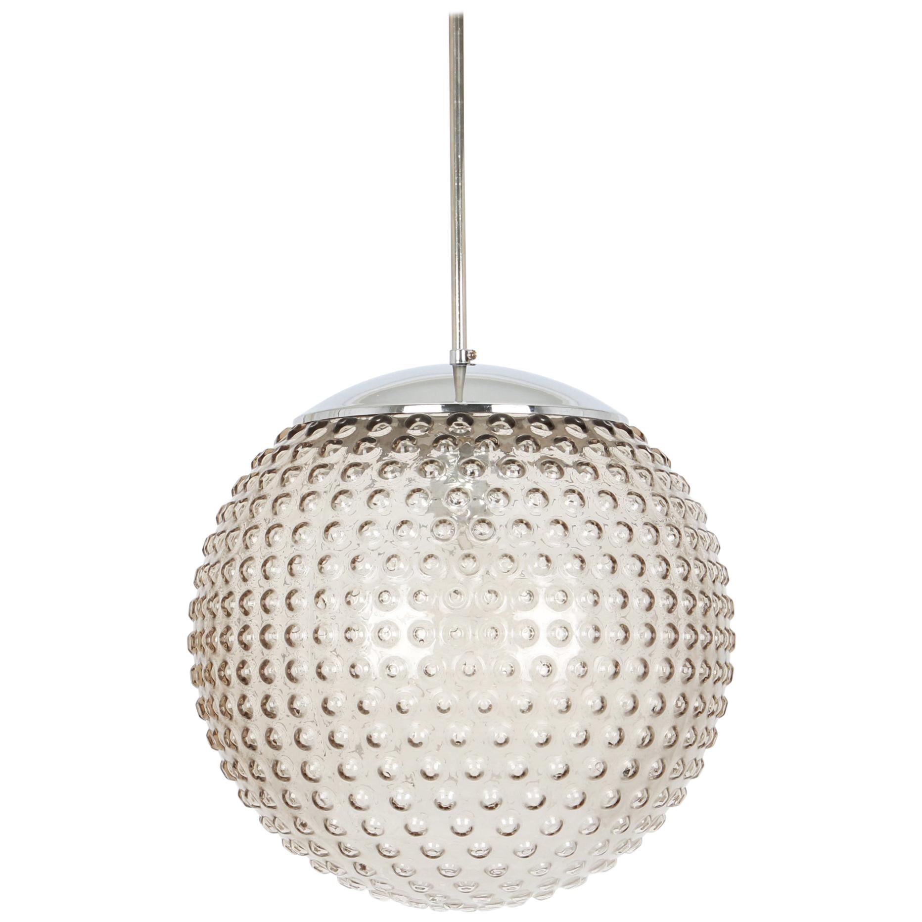 Rare designer smoked glass pendant lamp by Rolf Krüger for Staff, Germany, 1970s, Germany, circa 1970-1979.

Sockets: One x E27 standard bulb (max. 100 Watts) and compatible also with the US standards

Measures: Diameter 33 cm // 13