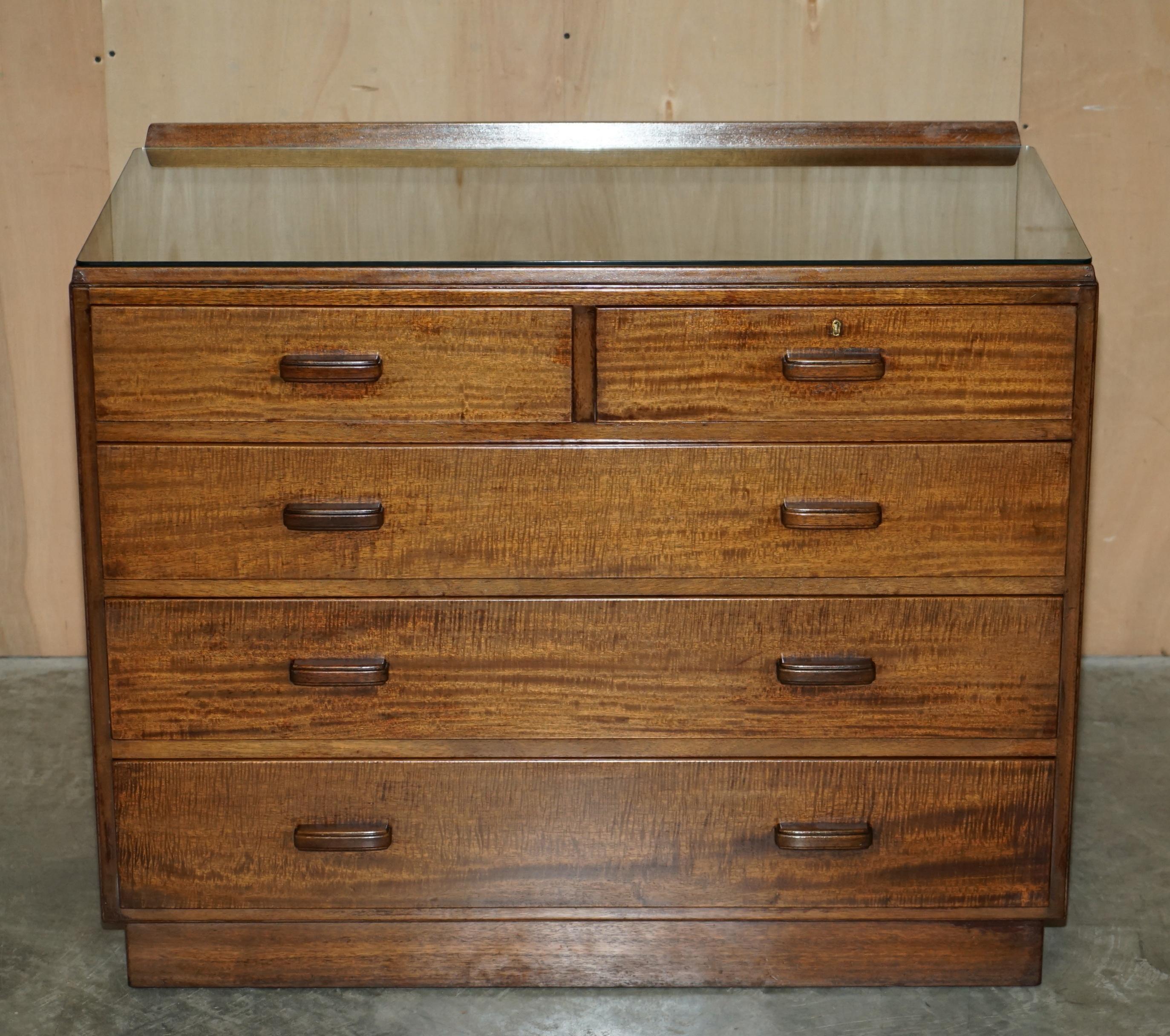 We are delighted to offer for sale this stunning original Alfred Cox circa 1952 Mid-Century Modern chests of drawers which are part of a suite.

This is a very well made chest, a very good size with a glass top and small lip at the back, the other