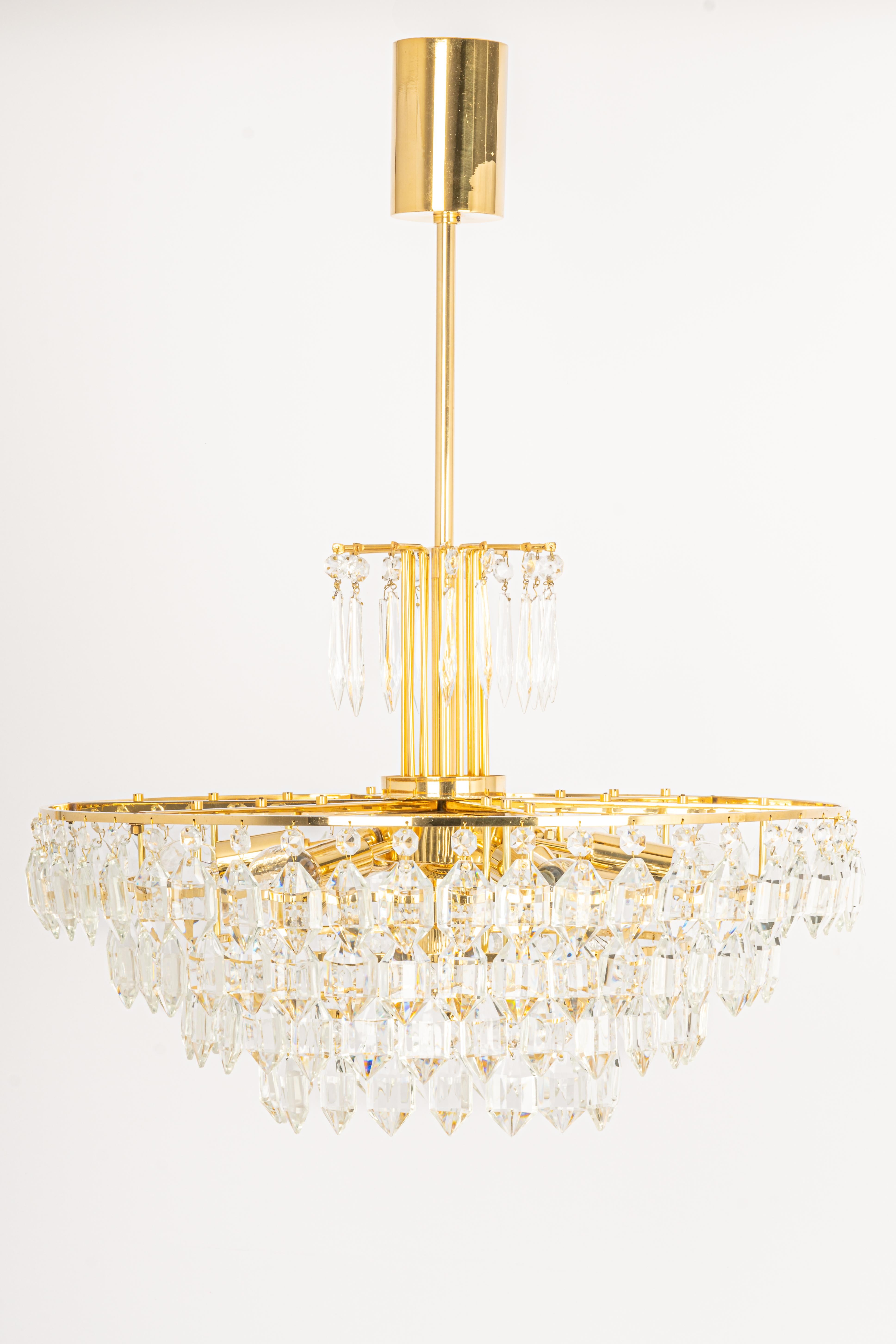 A stunning five-tier chandelier by Bakalowits & Sohne, Austria, manufactured in circa 1960-1969. A handmade and high-quality piece. The ceiling fixture and the frame are made of gilt brass and have five rings with lots of facetted crystal glass