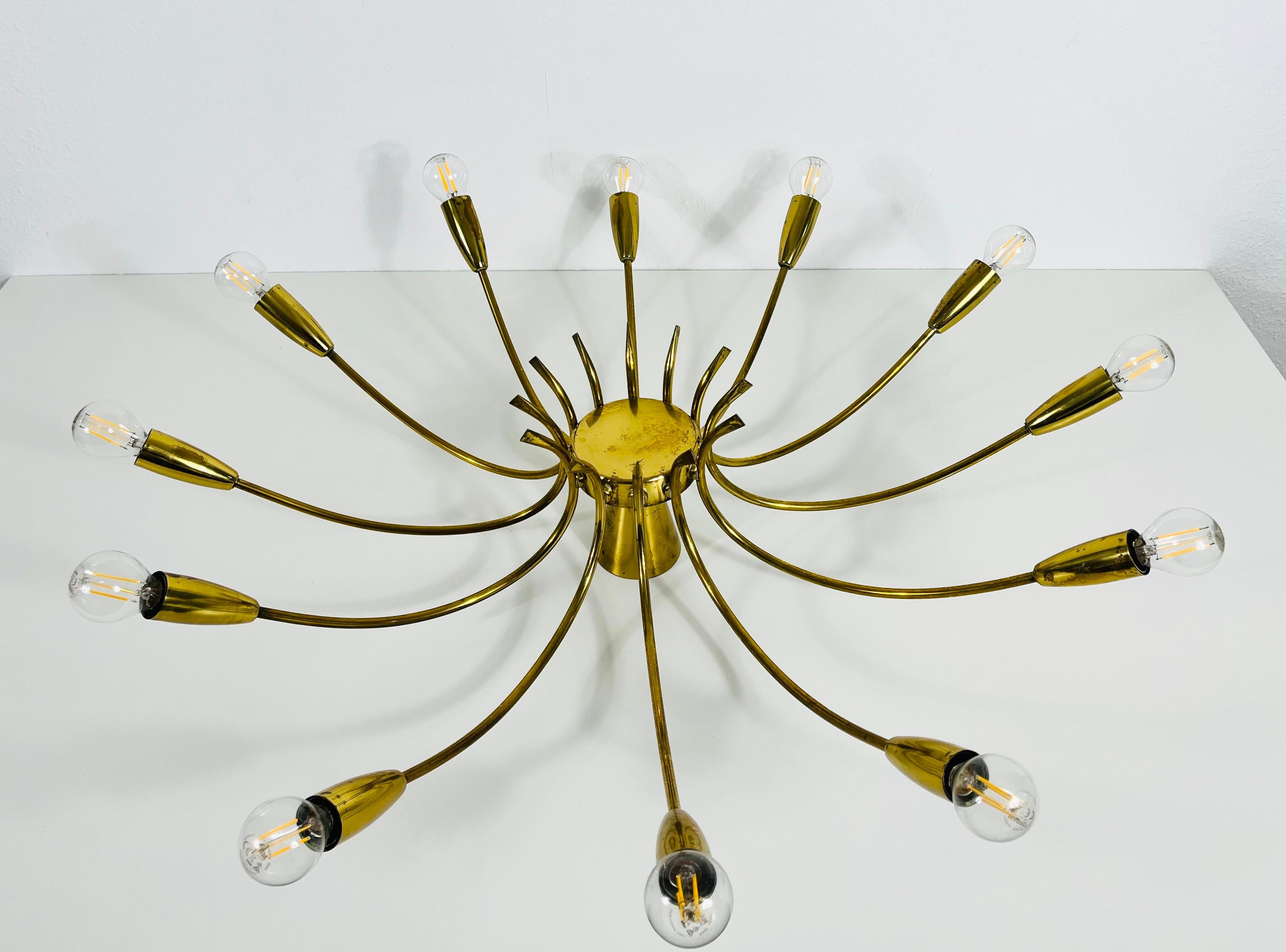 A Sputnik chandelier made in Italy in the 1950s. It is fascinating with its twelve brass arms, each of it with an E14 light bulb. The shape of the light is similar to a spider.

The light requires 12 E14 light bulbs. Works with both 120/220V. Good