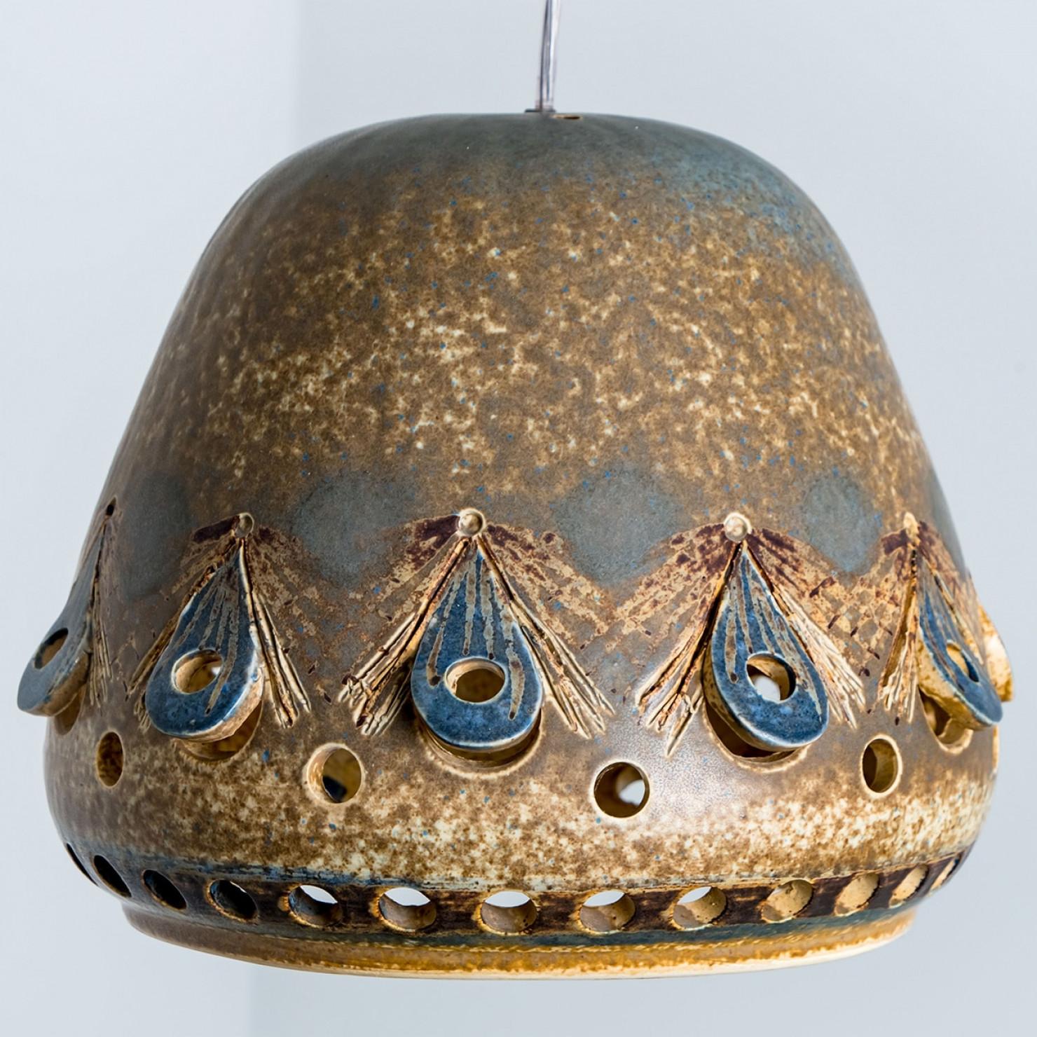 Stunning round pendant lamp with an unusual shape, made with rich colored brown and beige ceramics, manufactured in the 1970s in Denmark.

Dimensions:
Diameter: 11.81