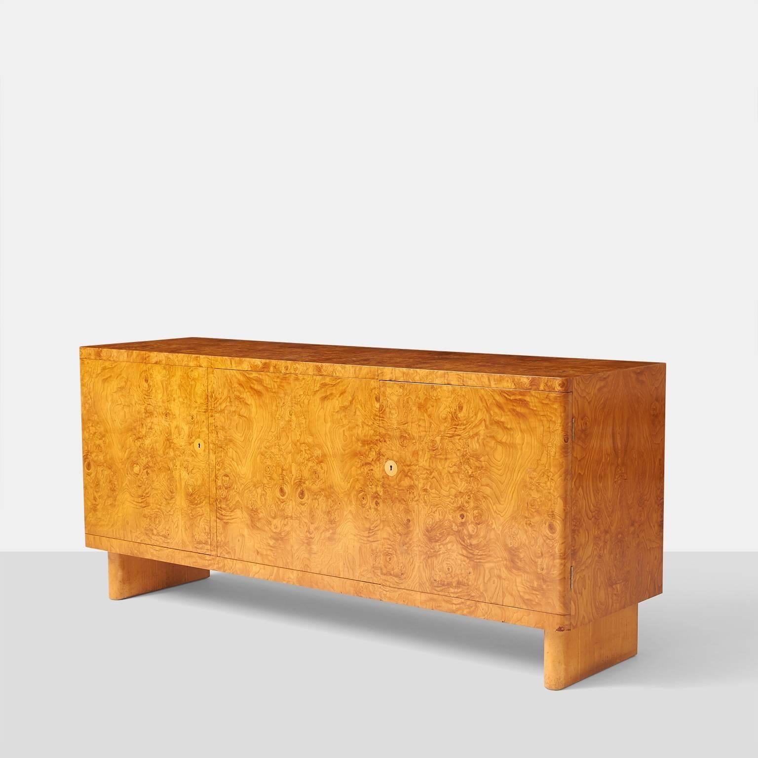 1 of 2 Deposit for James

A rare root wood veneered sideboard designed in 1935 by Architect Axel Einar Hjorth. Cabinet has three doors with adjustable shelves on two right sections and the left side having three felt lined pull out drawers. The