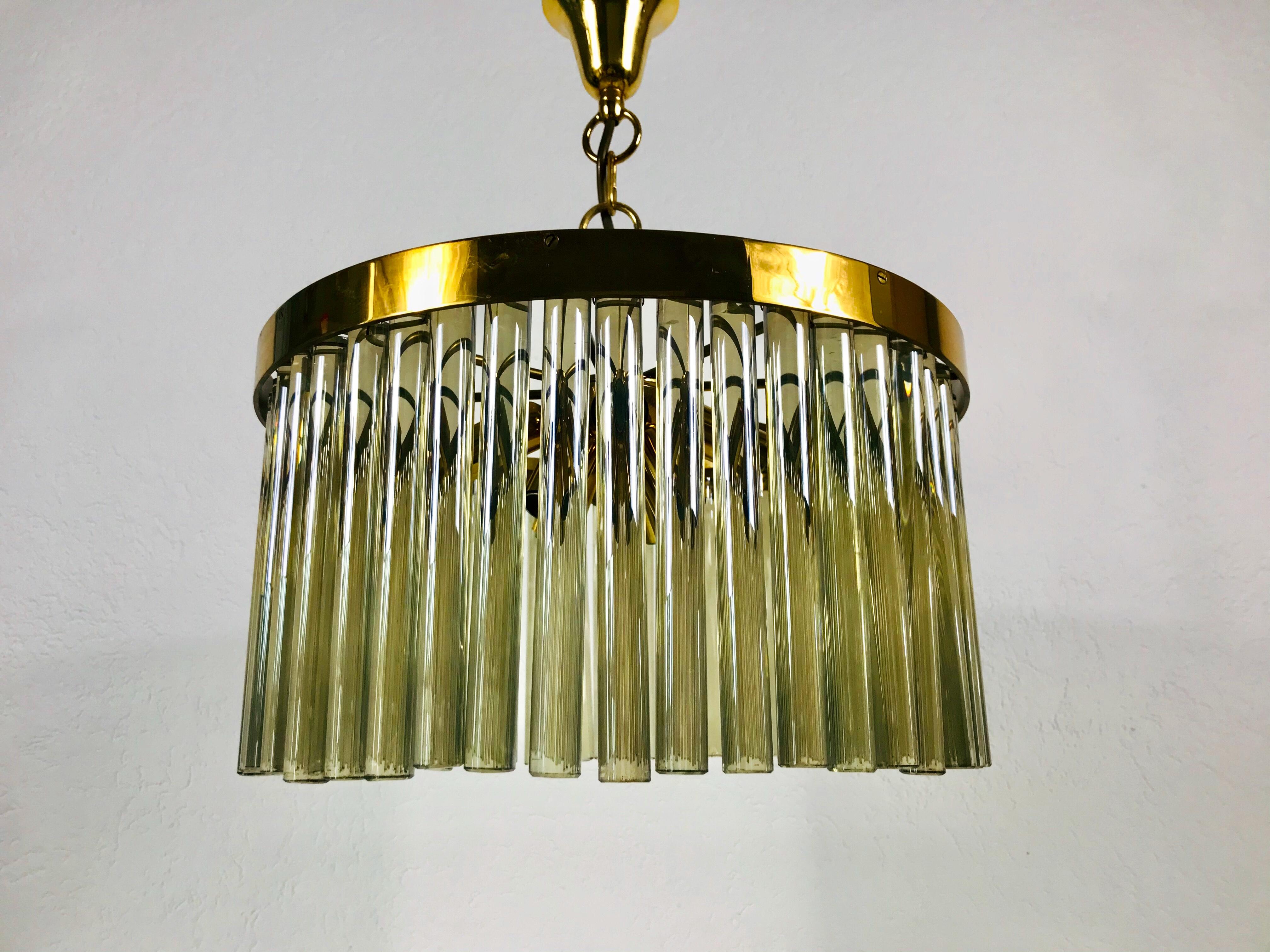 An extraordinary chandelier by Christoph Palme made in Germany in the 1960s. The lamp has a very elegant design and is also very heavy. It is made in the period of Hollywood Regency. Round golden gilded brass body with E14 sockets. The body is