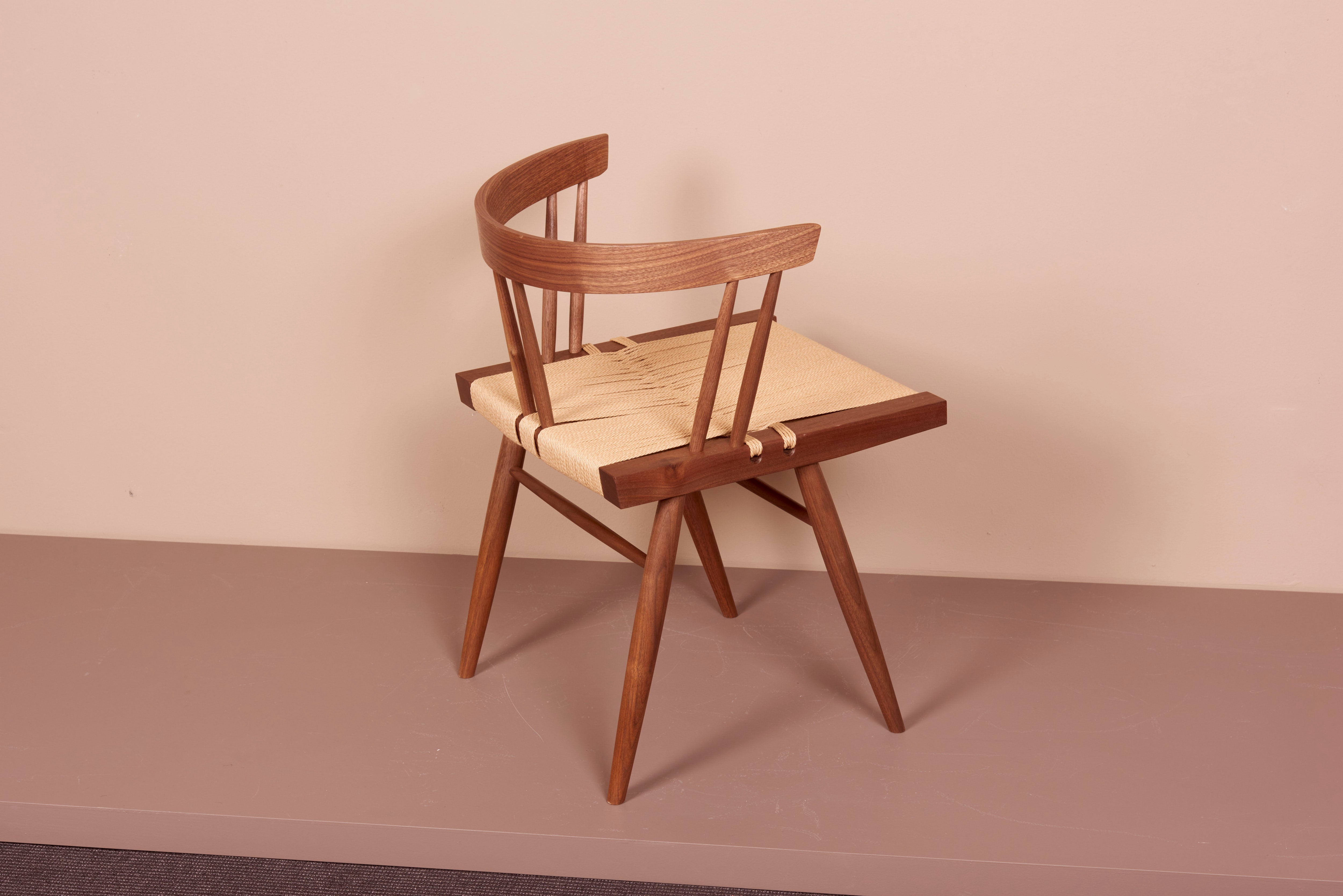 grass-seated chair, designed by George Nakashima and manufactured by George Nakashima Studio in the US. The square seat typically found in walnut and woven sea-grass. One chair is in stock and available now, more is available on order (please