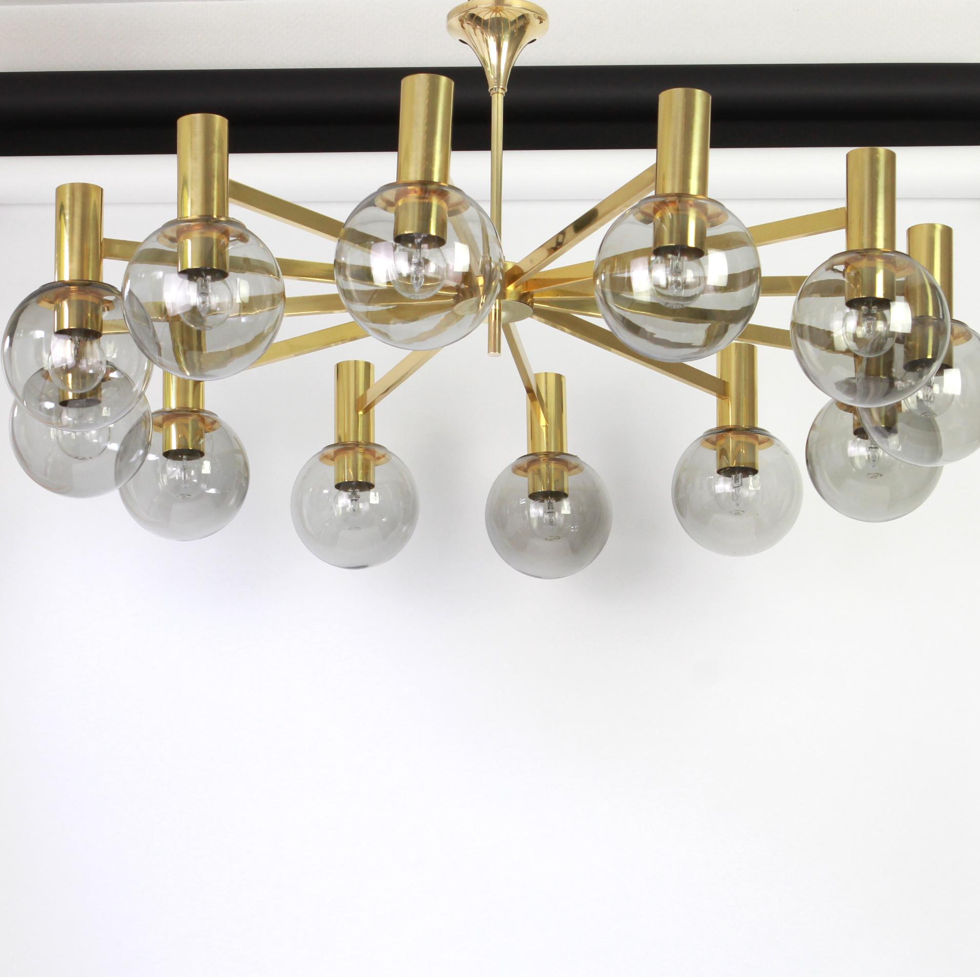 Twelve-light brass chandelier.
Smoked glass in a very beautiful Smokey brown color.
Made with brass and brass-plated metal, best of the 1960s.

High quality and in very good original condition. Cleaned, well-wired and ready to use. 

The fixture