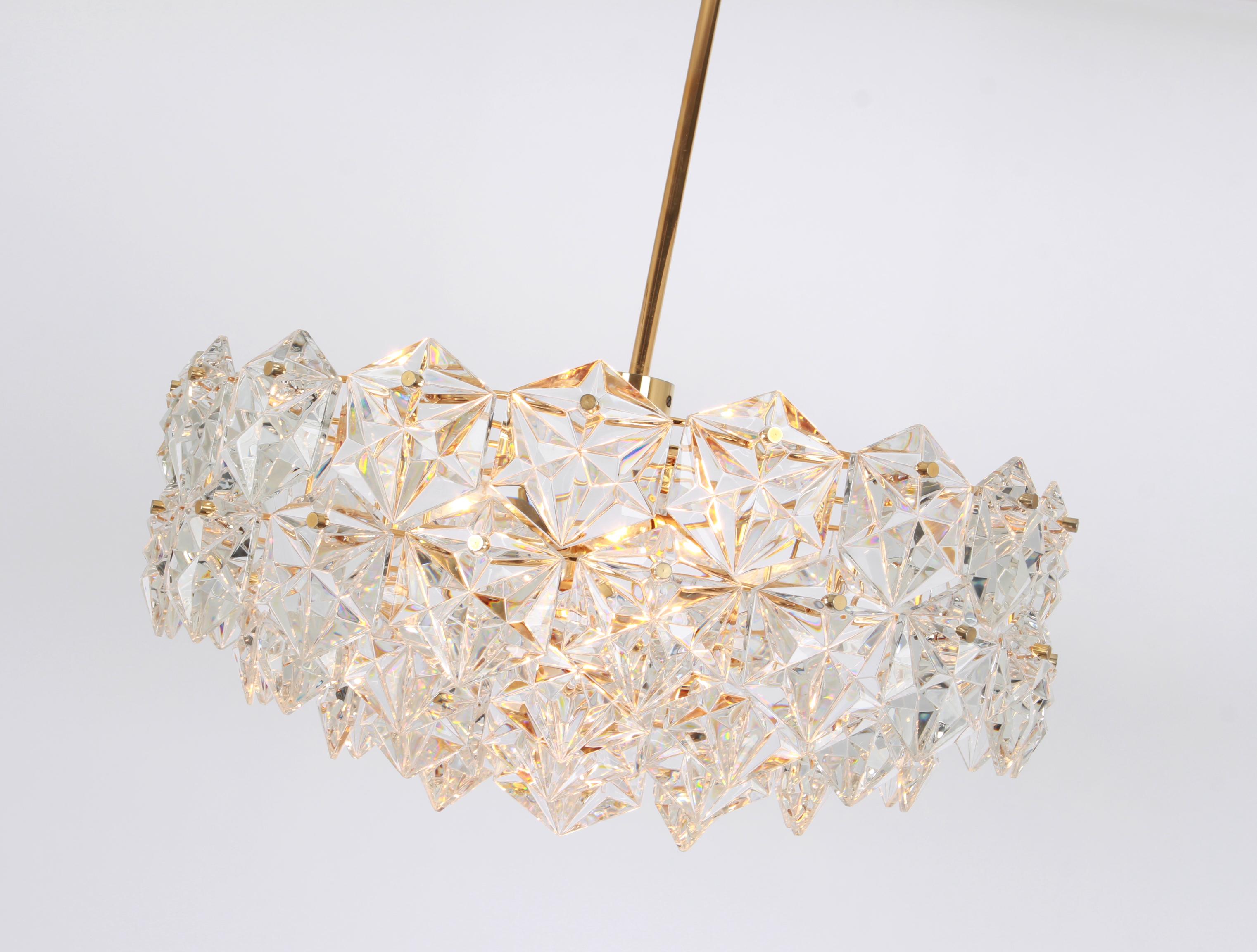 A stunning five-tier chandelier by Kinkeldey, Germany, manufactured in circa 1970-1979. A handmade and high-quality piece. The chandelier features a 24-karat gold-plated four-tier structure with lots of facetted crystal glass elements.

High