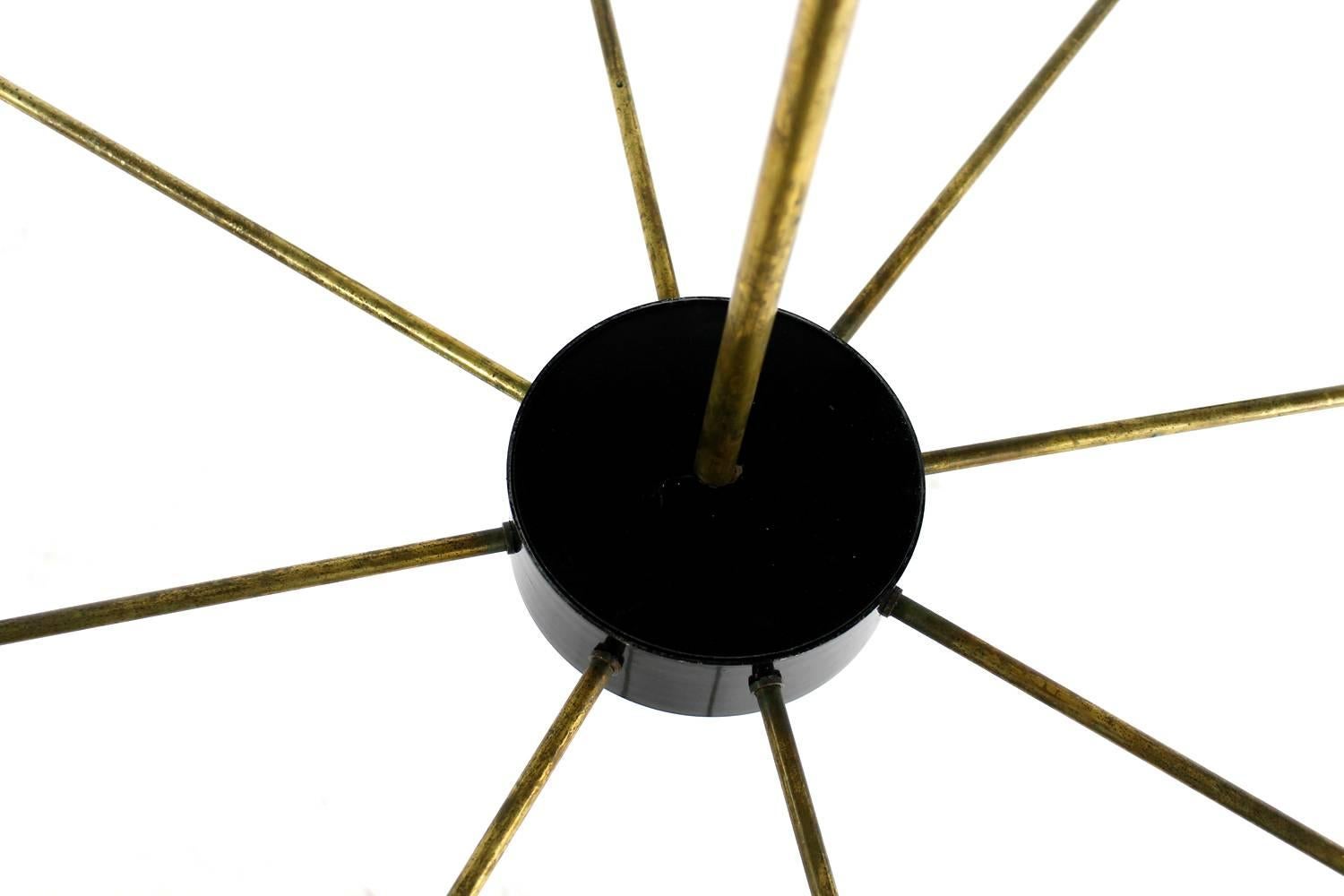 Bellissimo lampadario italiano in metallo in stile Stilnovo. Otto bracci e 16 lampadine fino a 40W ciascuna, con una bella patina sulle parti in ottone, le parti metalliche sono laccate in nero, il lampadario è già stato ricablato. Nel complesso una