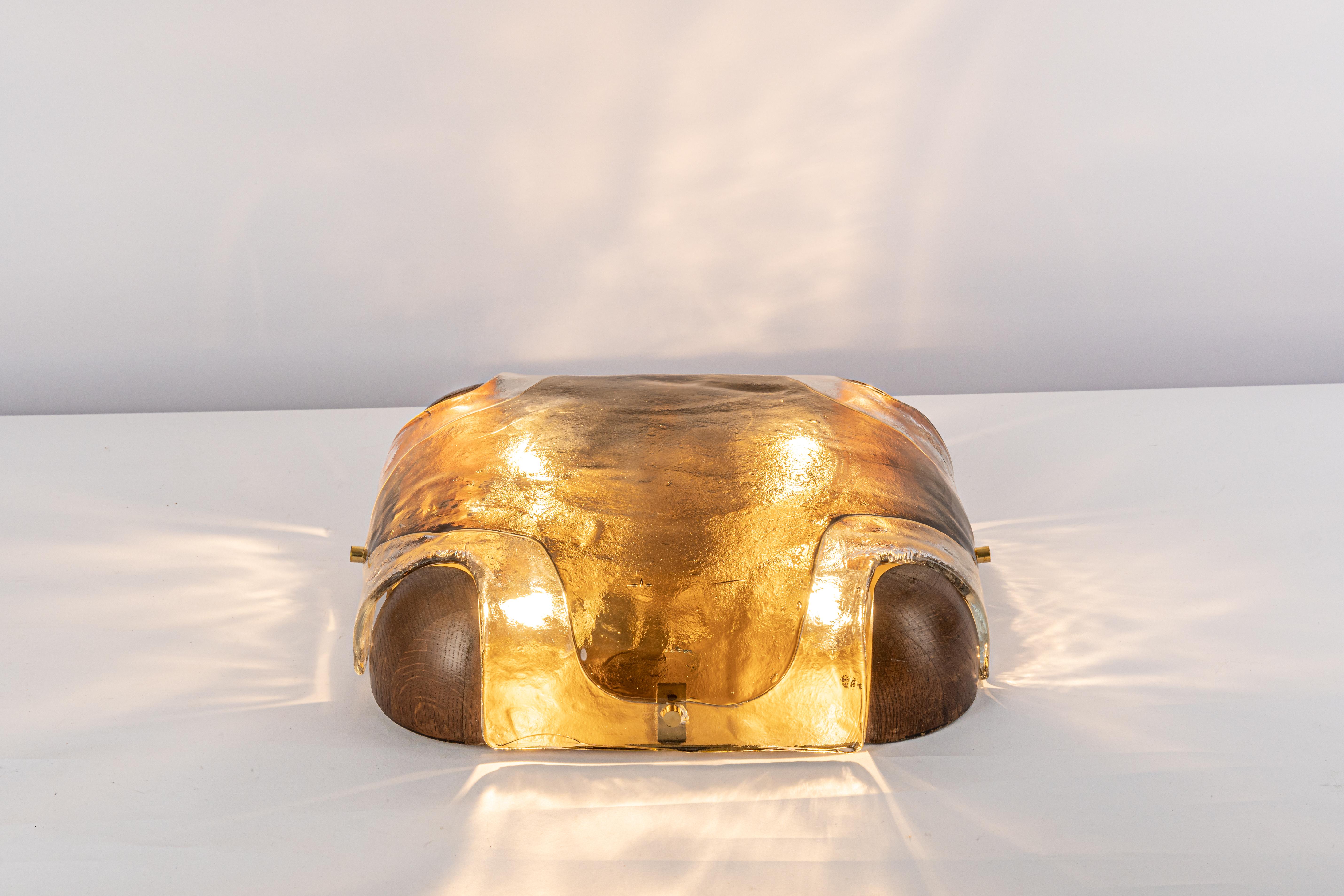 A wonderful Murano glass flush mount by Kaiser, Germany, 1970s.
Thick textured Glass fixtured on a wood and gold color metal base.

High quality and in very good condition. Cleaned, well-wired, and ready to use. 

The fixture requires 4 x E27