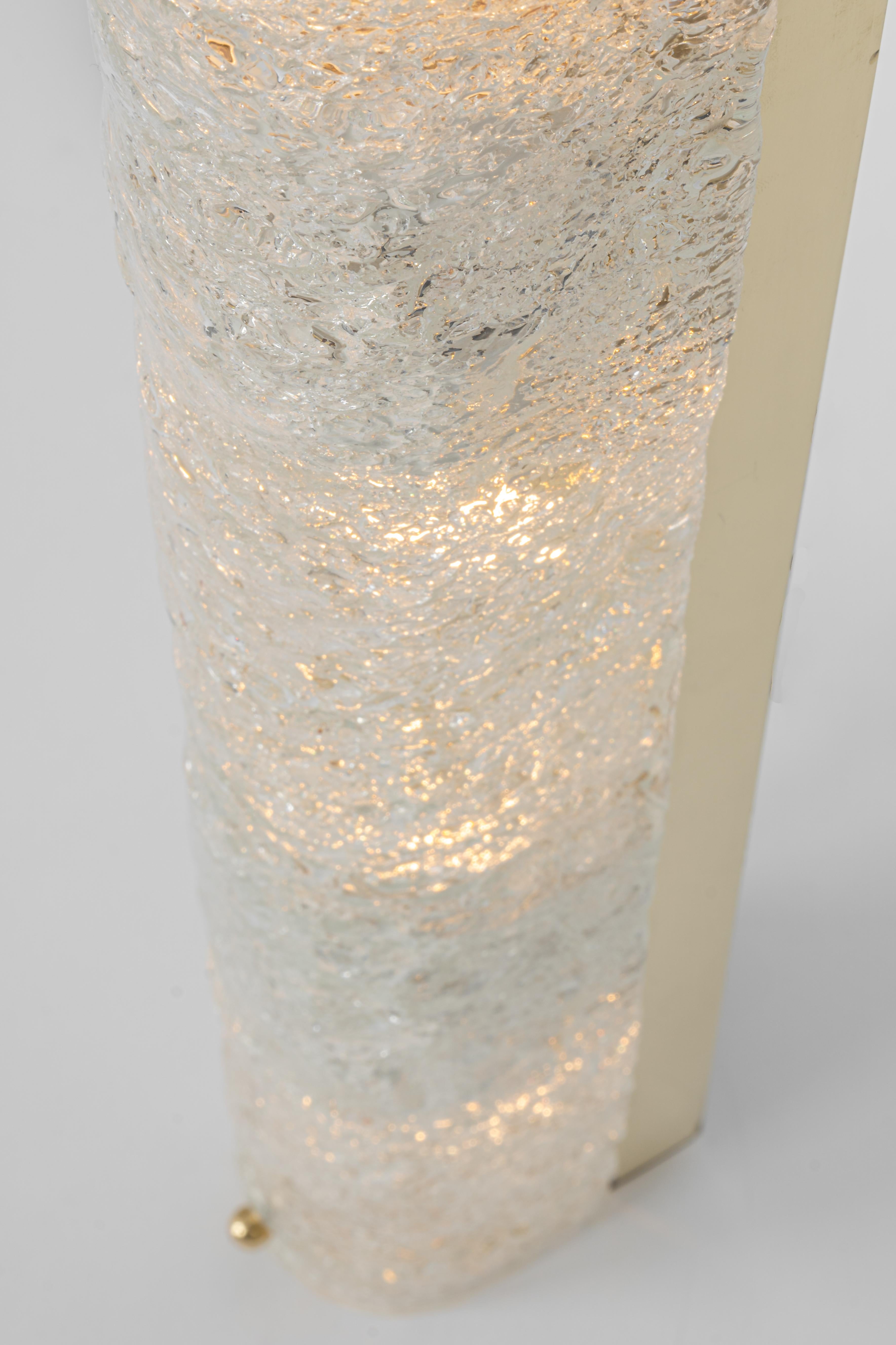 1 of 2 large handcrafted Murano glass on a brass base sconces by Hillebrand, Germany, circa 1960s.

It consists of textured quality clear crystal tubular shade simulating ice on a Brass frame.
The design allows this light to be placed either