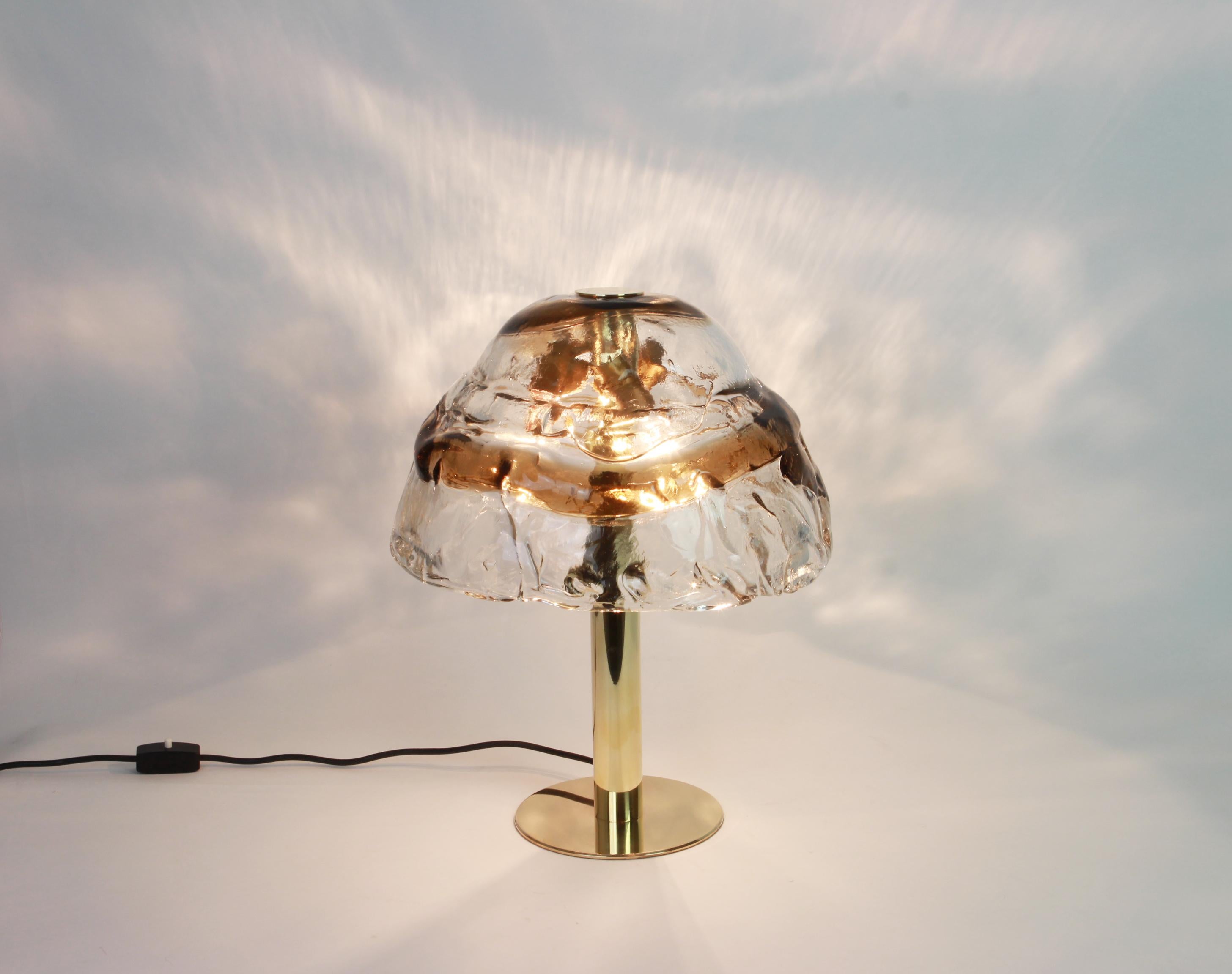 Superbe lampe de table en verre de Murano par Kalmar, 1970
Verre de Murano tourbillonnant fumé, panneaux de verre en cristal clair torsadé avec une bande de couleur ambre légèrement dorée.

Il nécessite 3 ampoules E27 standard. (Max 50 watts