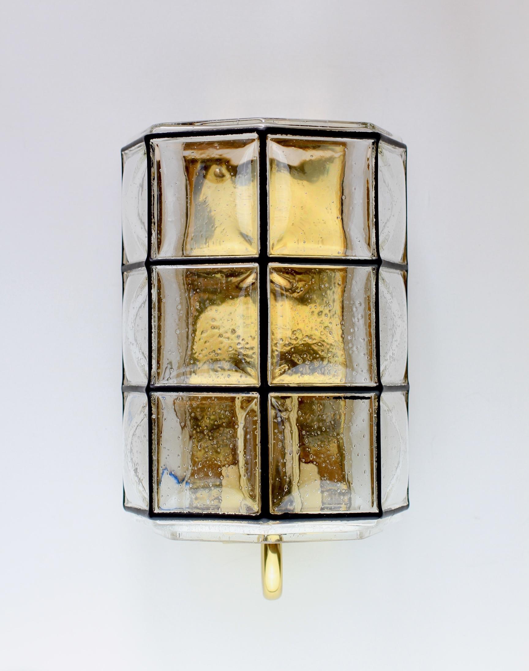 Una coppia di lampade o applique da parete Limburg, minimali, geometriche e dalla forma semplice. Queste eleganti lampade vintage di metà secolo sono caratterizzate da un paralume in vetro a bolle soffiato a bocca, realizzato a mano, che fuoriesce