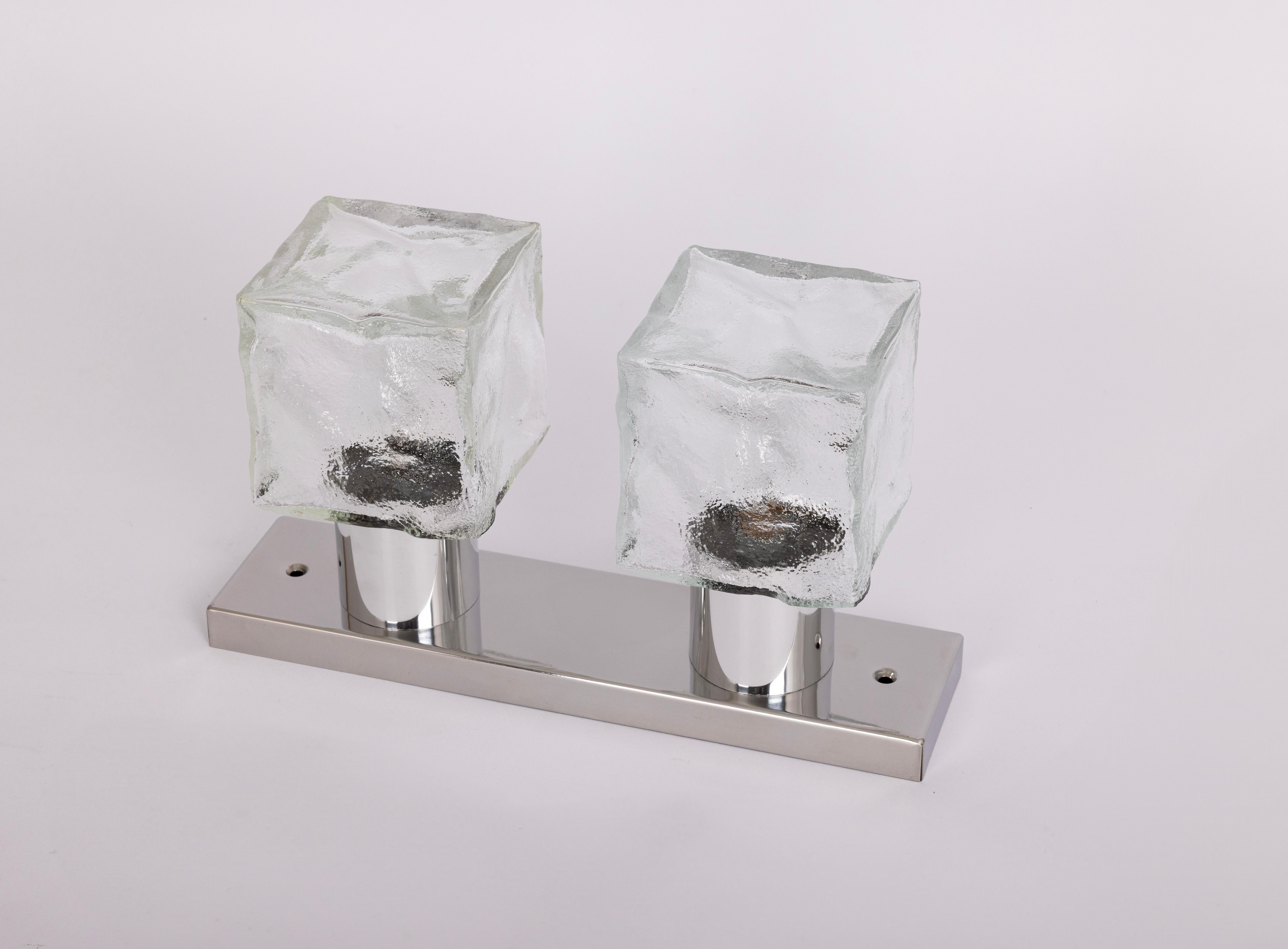 1 di 2 lampade da parete in vetro ghiaccio di Murano prodotte negli anni '60 da Kalmar, Austria.
L'applique è composta da un cubo di vetro di Murano spesso 2 mm fissato a una struttura in metallo cromato.
Un meraviglioso effetto di luce.

Di qualità