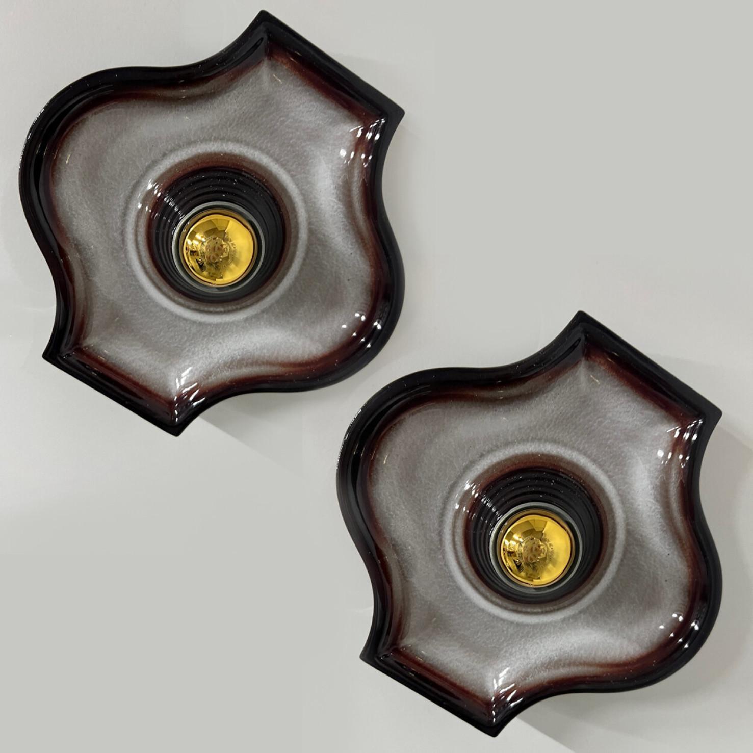 Oval grey and brown ceramic wall lights in Fat Lava style. Manufactured by Hustadt Leuchten Keramik, Germany in the 1970s.

The style of the glaze is called 'Fat Lava'. Which means the glaze is thick on some parts, like lava.
A typical way to finish
