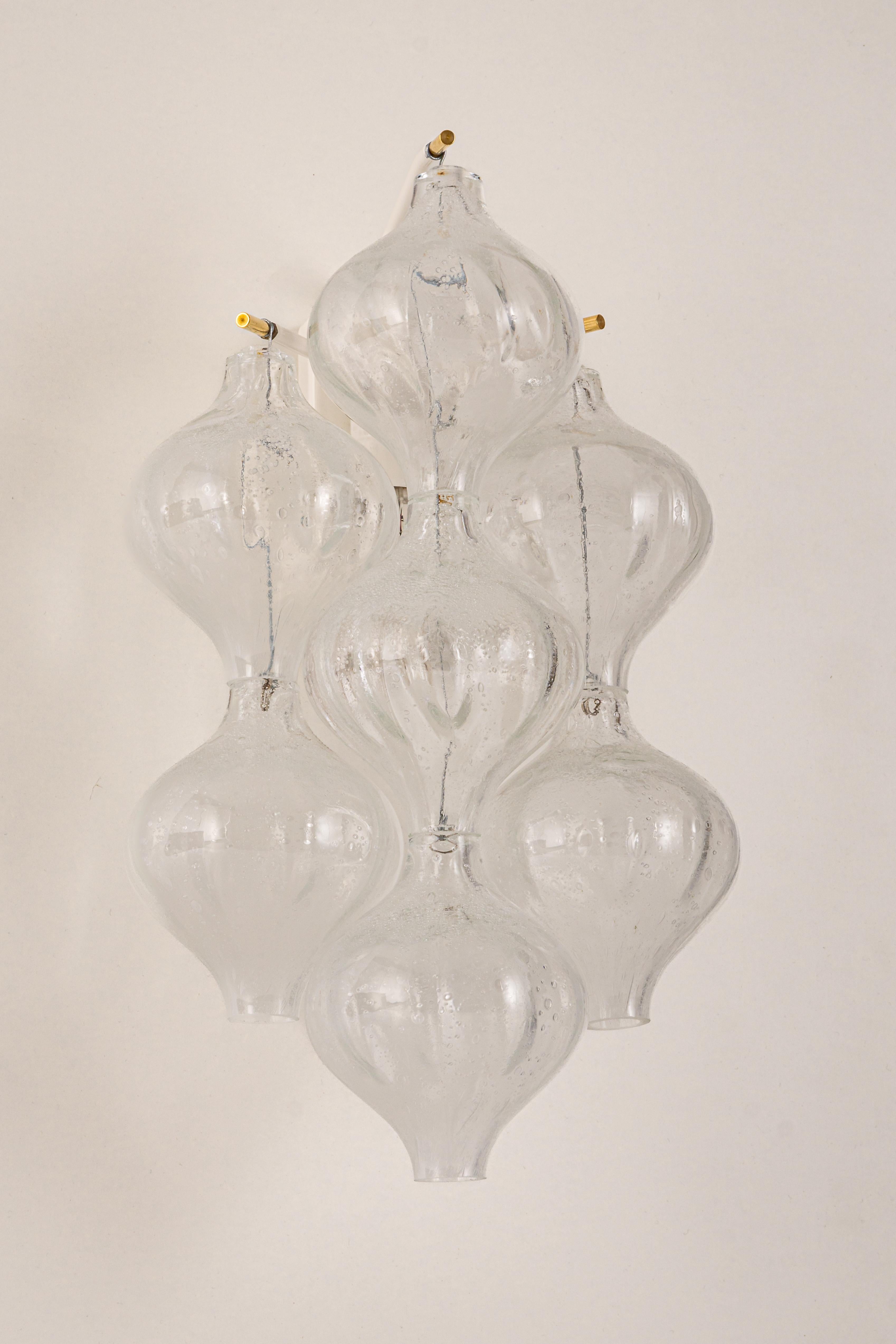 Wonderful pair of mid-century wall sconces, made by Kalmar, Austria, manufactured, circa 1970-1979.
Each tulip-shaped glass is handmade which makes each glass piece is a unique piece. Each sconce is made of 7 glass pieces on a white enameled metal