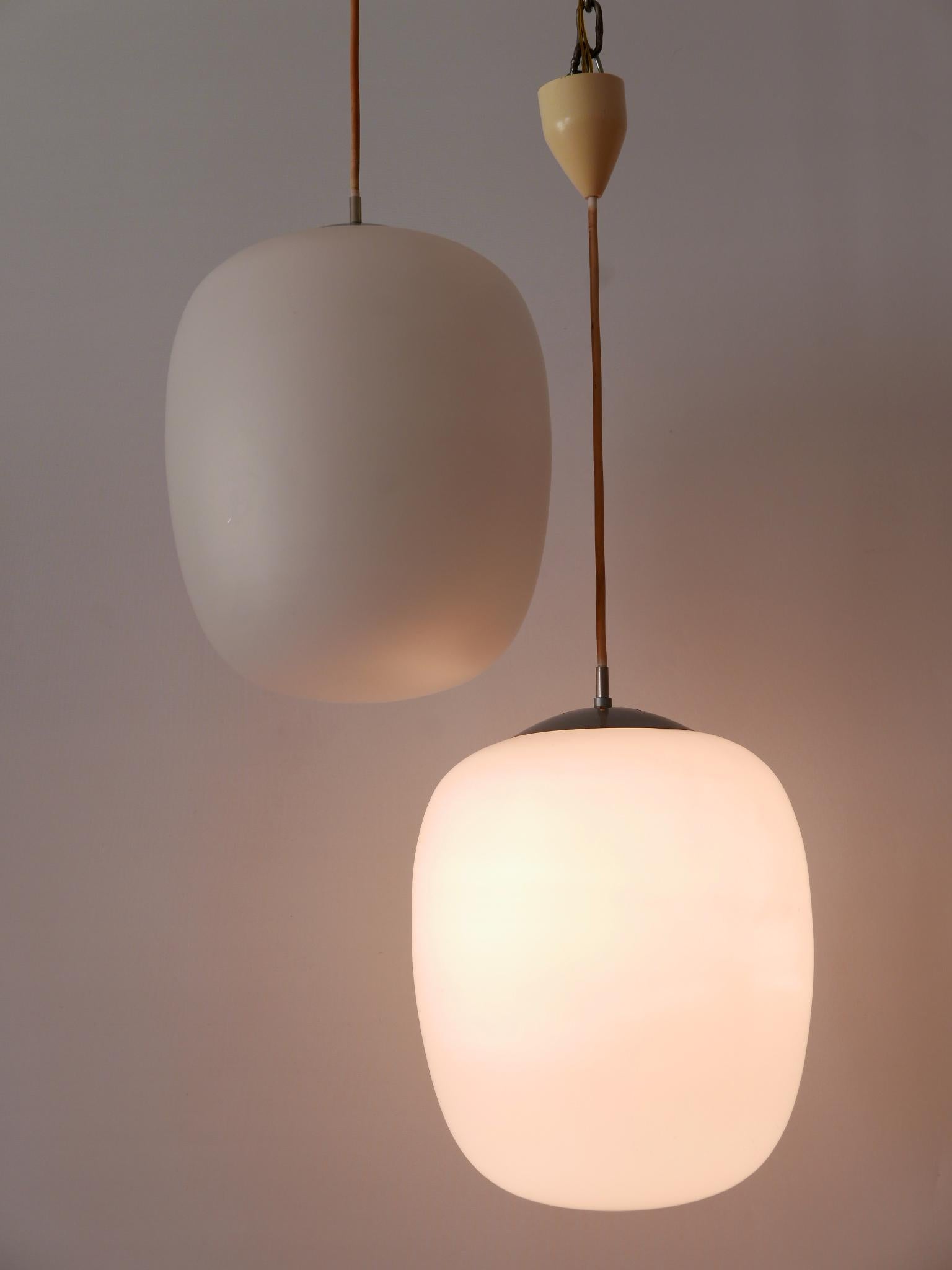 Elegant Mid-Century Modern pendant lamp or hanging light. Model 'Düren'. Designed by Wilhelm Wagenfeld for Peill & Putzler, Germany, 1952. Manufactured in 1950s.

Executed in opaline glass , the pendant lamp needs 1 x E27 / E26 Edison screw fit
