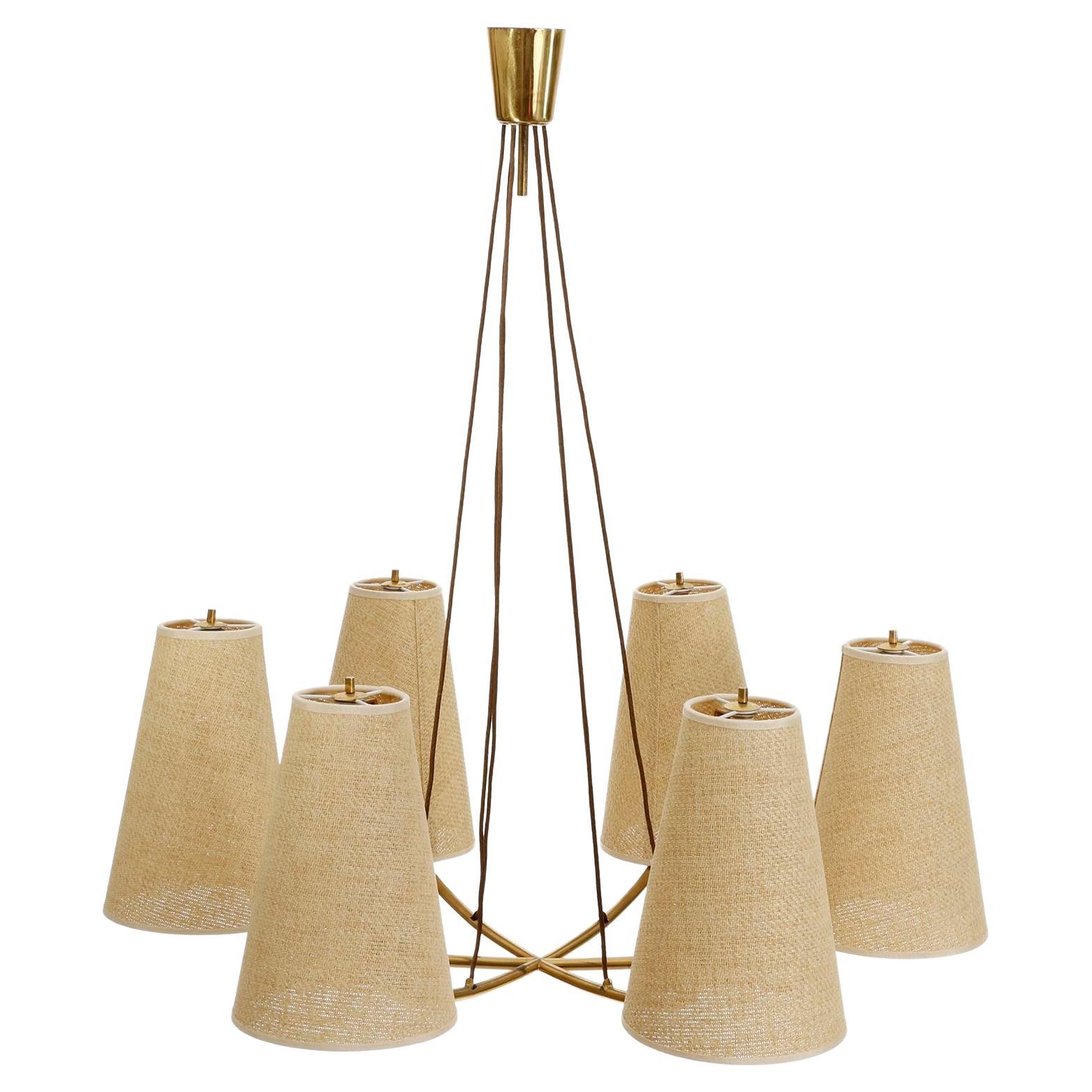 One of two large pendant lamps model no. 3635/6 'Mexiko' (engl. Mexico) by J.T. Kalmar, Austria, 1960s.
A brass star with six arms and cone shaped wicker or cane shades. Each chandelier has six sockets for medium or standard screw base bulbs.
The