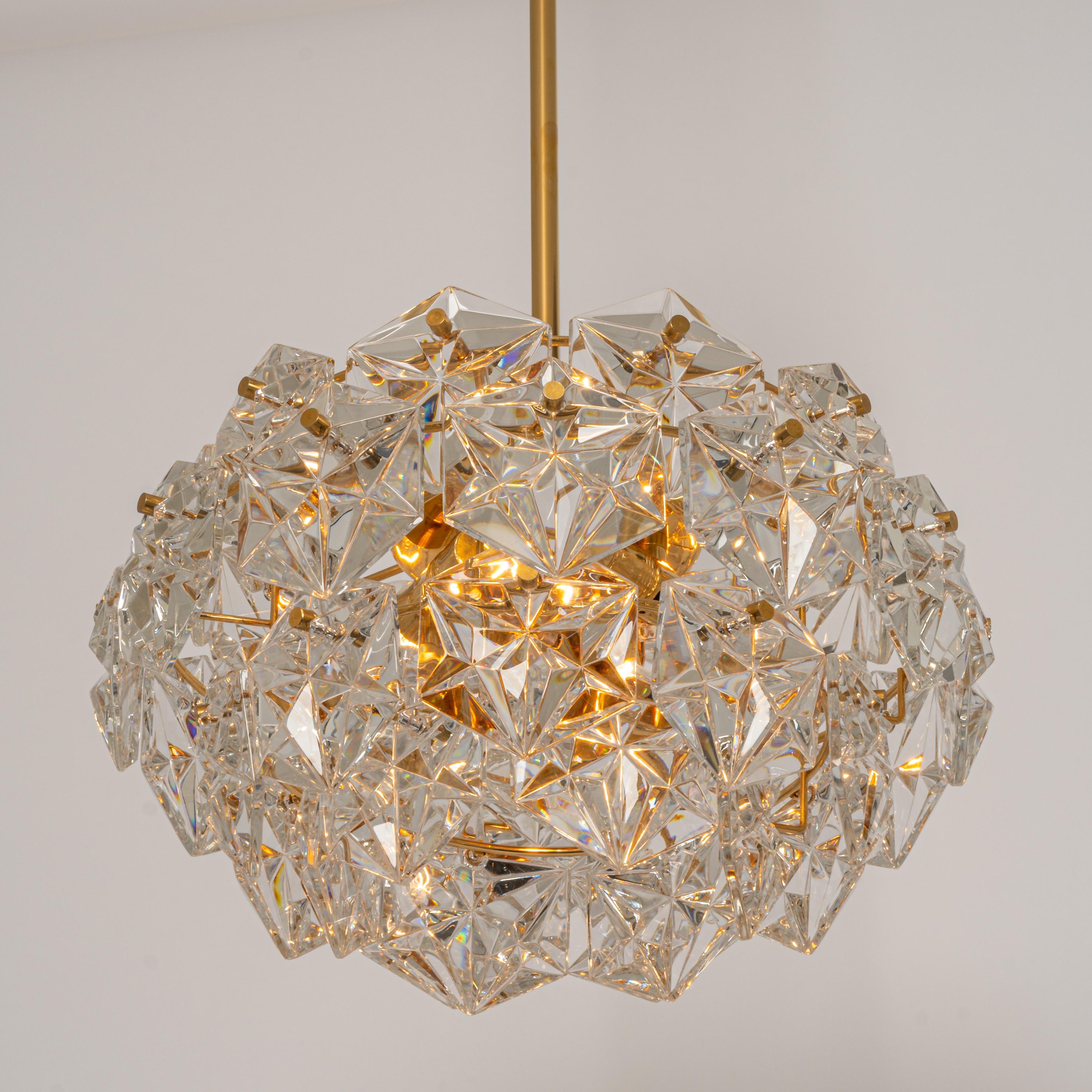 A stunning 4 chandelier by Kinkeldey, Germany, manufactured in circa 1970-1979. A handmade and high quality piece. The ceiling fixture and the frame are made of brass and has four rings with lots of facetted crystal glass elements.

High quality