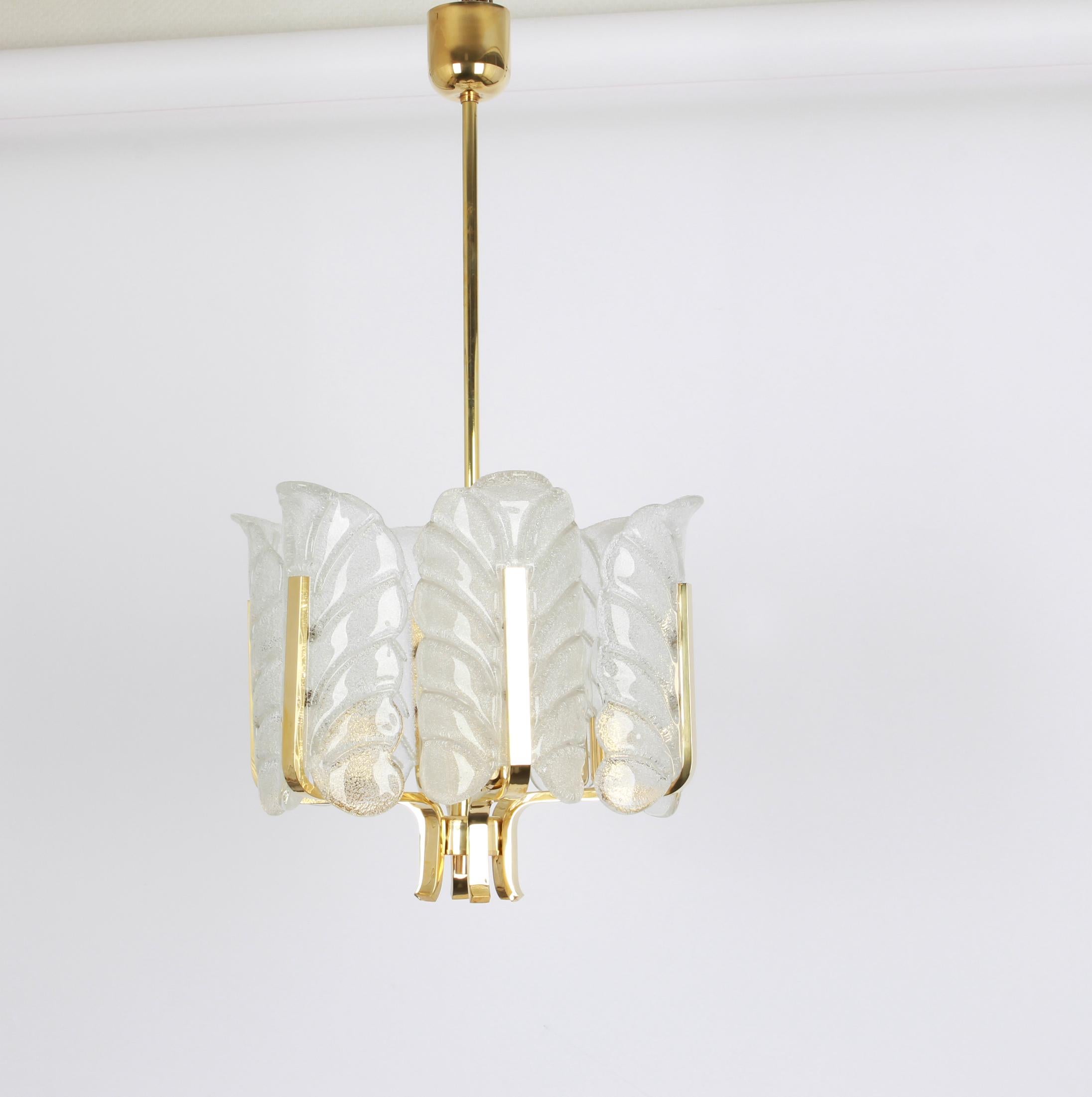 Very glamorous chandelier designed by Carl Fagerlund for Orrefors glass, Sweden, manufactured in midcentury, circa 1960-1969. The light features a polished brass frame with six stunning Murano glass leaves which have a matte frosted relief on the