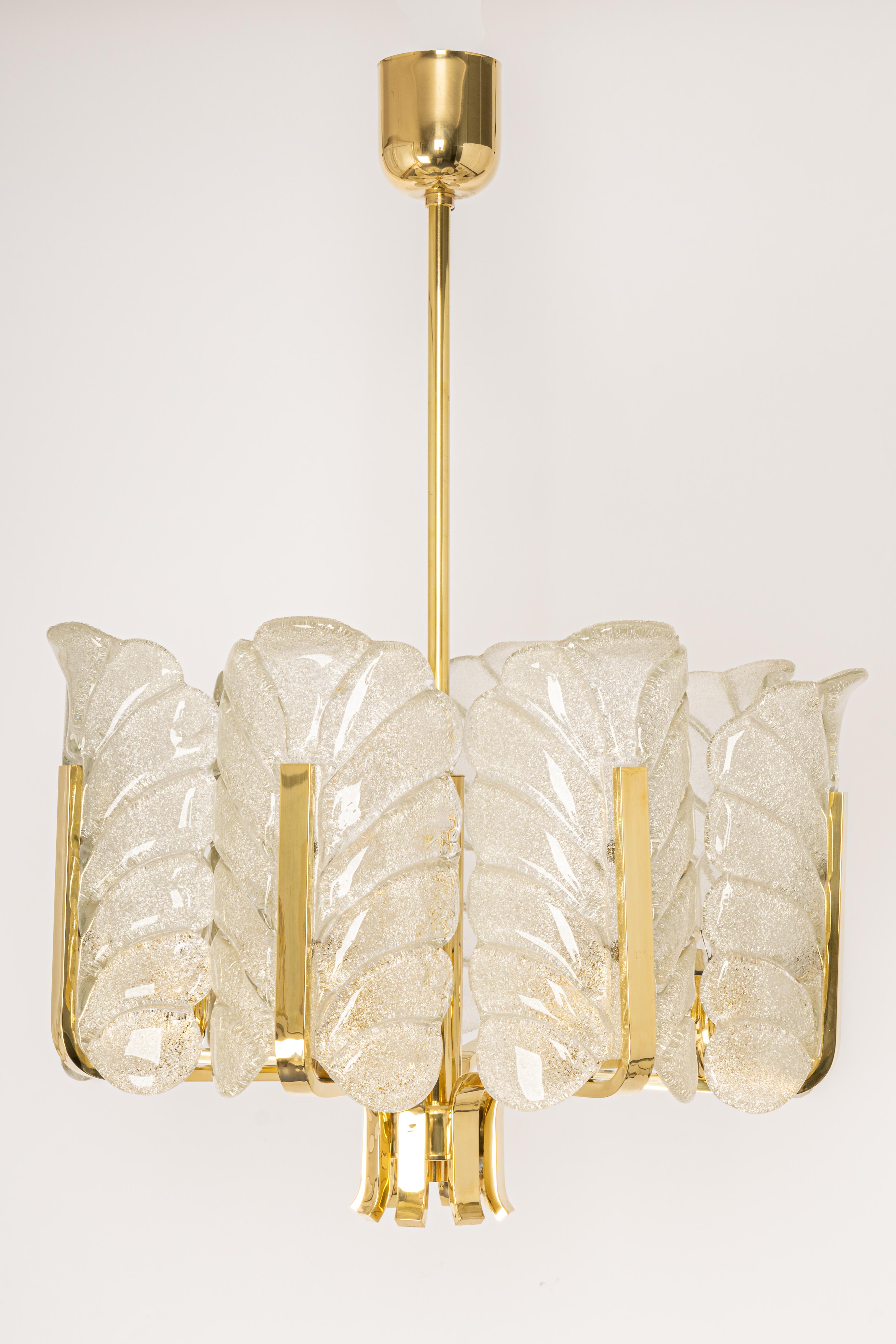 Very glamorous chandelier designed by Carl Fagerlund for Orrefors glass, Sweden, manufactured in midcentury, circa 1960-1969. The light features a polished brass frame with eight stunning murano glass leaves which have a matte frosted relief on the