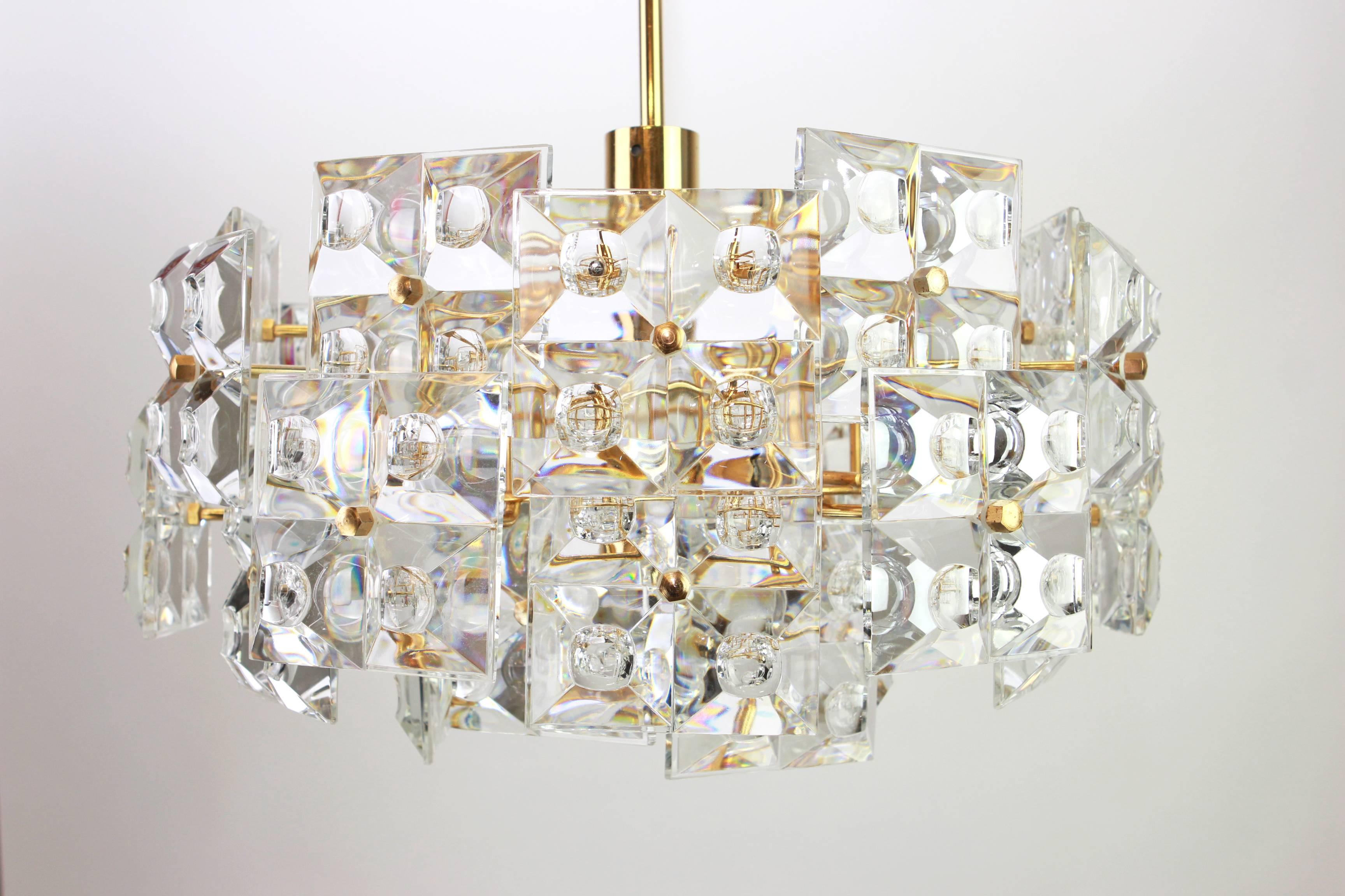 A stunning four-tier chandelier by Kinkeldey, Germany, manufactured in circa 1970-1979. A handmade and high quality piece. The ceiling fixture and the frame are made of brass and has four rings with lots of facetted crystal glass