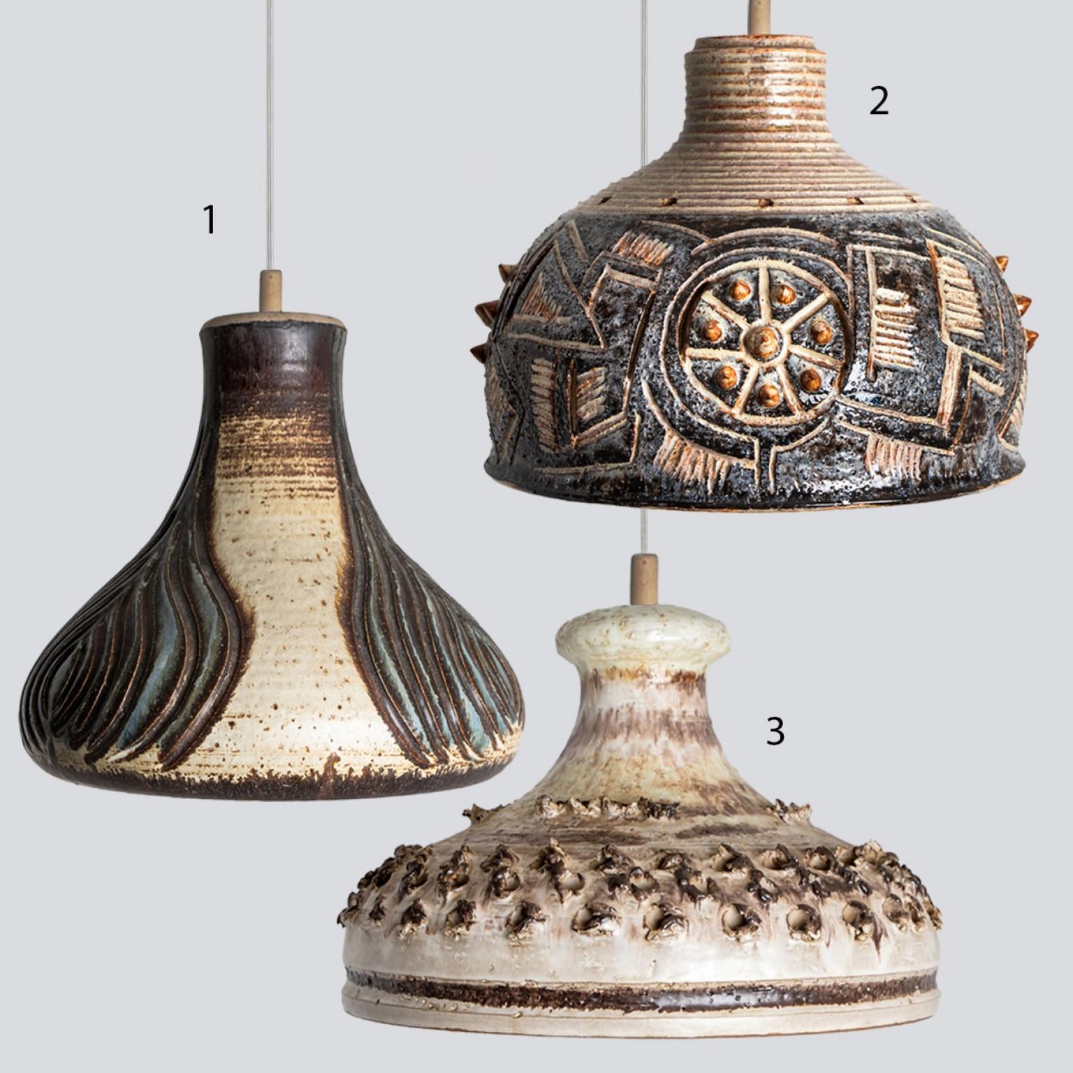 Una disposizione giocosa di splendide lampade a sospensione rotonde dalla forma insolita, realizzate con ceramiche color antracite, avorio, azzurro e marrone, prodotte negli anni '70 in Danimarca. Abbiamo una moltitudine di set e composizioni di