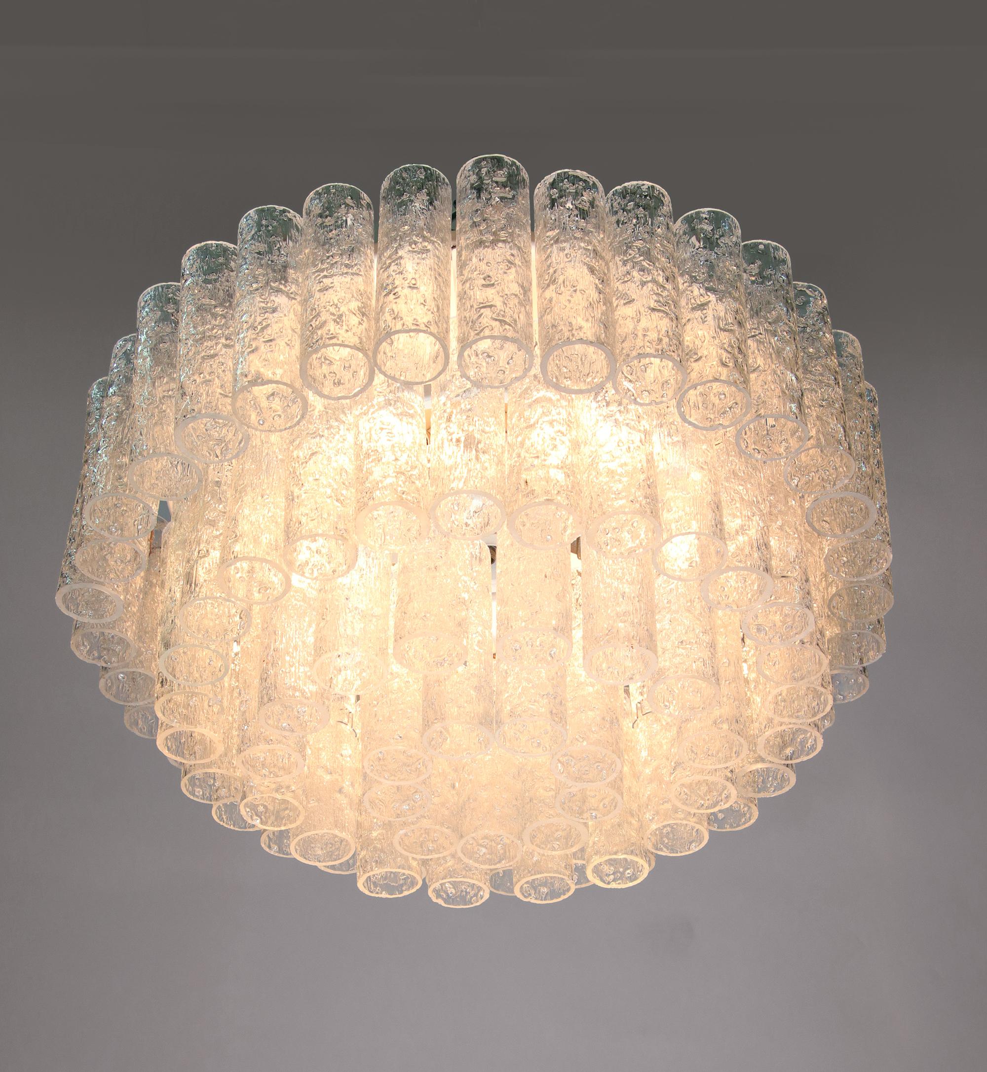 Elegant plafonnier à quatre niveaux avec de nombreux tubes texturés en verre de Murano suspendus à une armature en métal émaillé blanc. Le lustre éclaire magnifiquement et offre beaucoup de lumière. Gemme de l'époque. Avec ce luminaire, vous faites